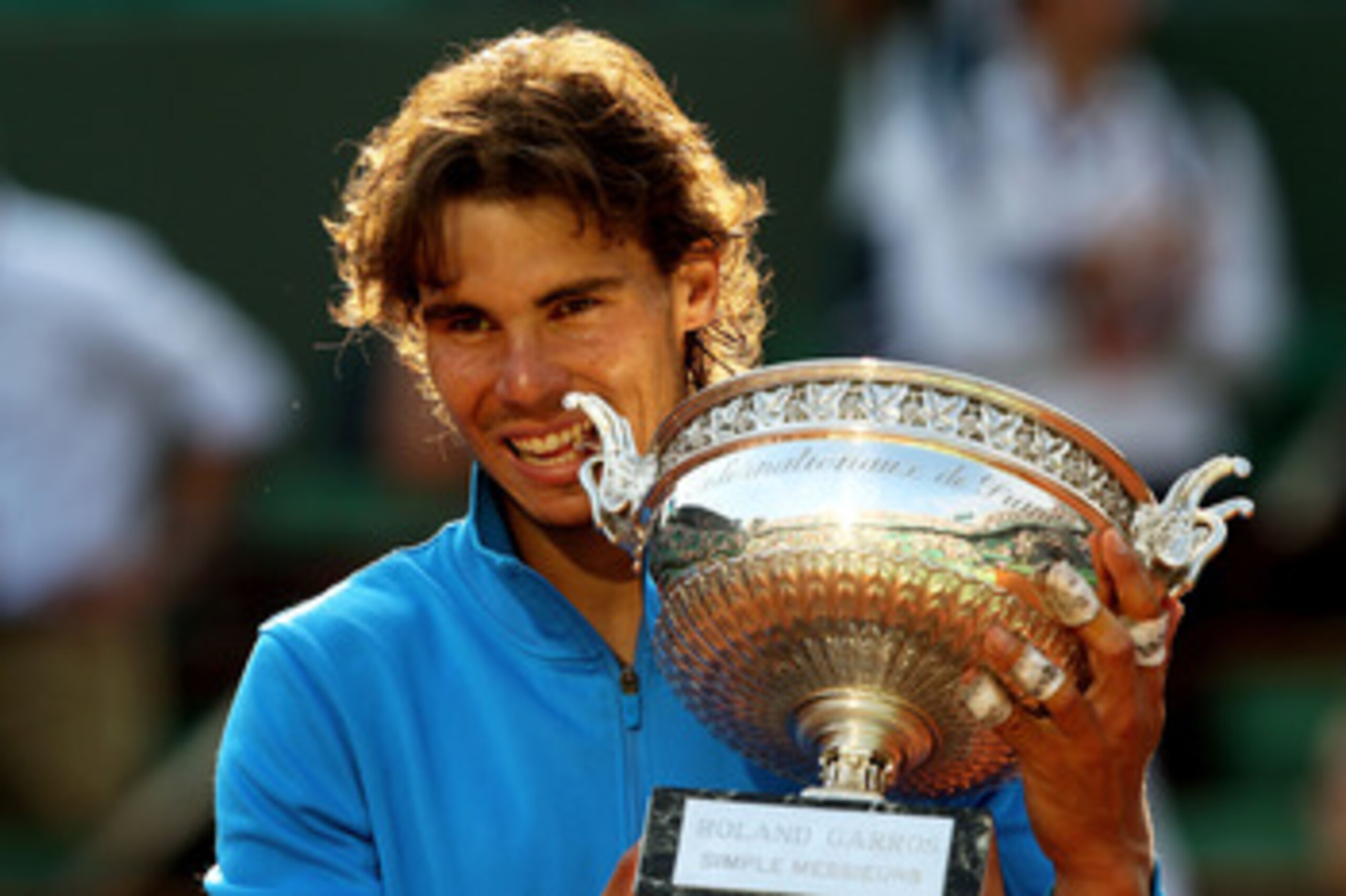 PARIS, FRANCE - JUNE 05:  Champion Rafael Nadal of Spain bites the trophy following his record equalling sixth victory during the men's singles final match between Rafael Nadal of Spain and Roger Federer of Switzerland on day fifteen of the French Open at
