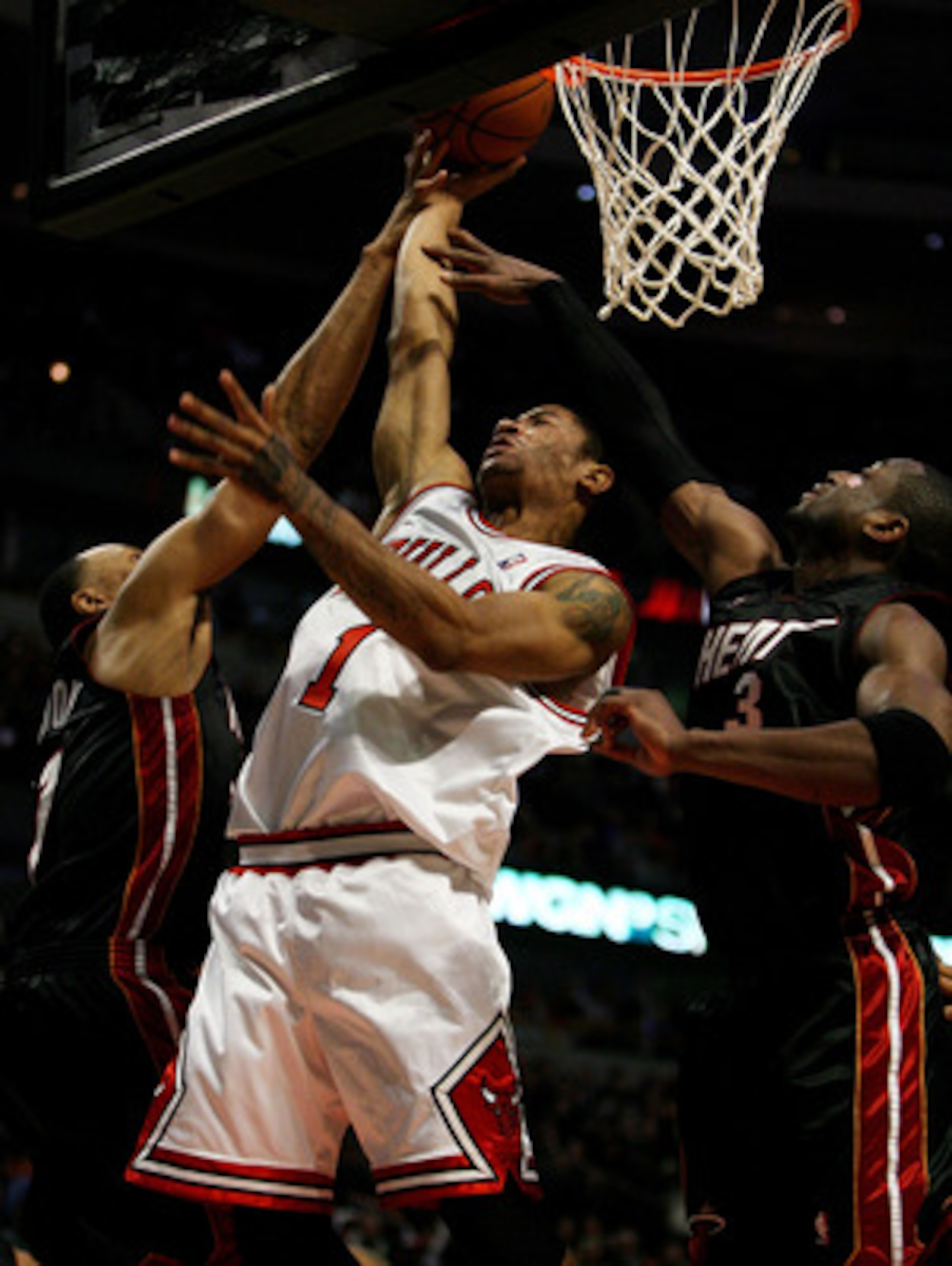 CHICAGO - FEBRUARY 12:  Derrick Rose #1 of the Chicago Bulls puts up a shot between Shawn Marion #7 and Dwyane Wade #3 of the Miami Heat on February 12, 2009 at the United Center in Chicago, Illinois. The Heat defeated the Bulls 95-93. NOTE TO USER: User 