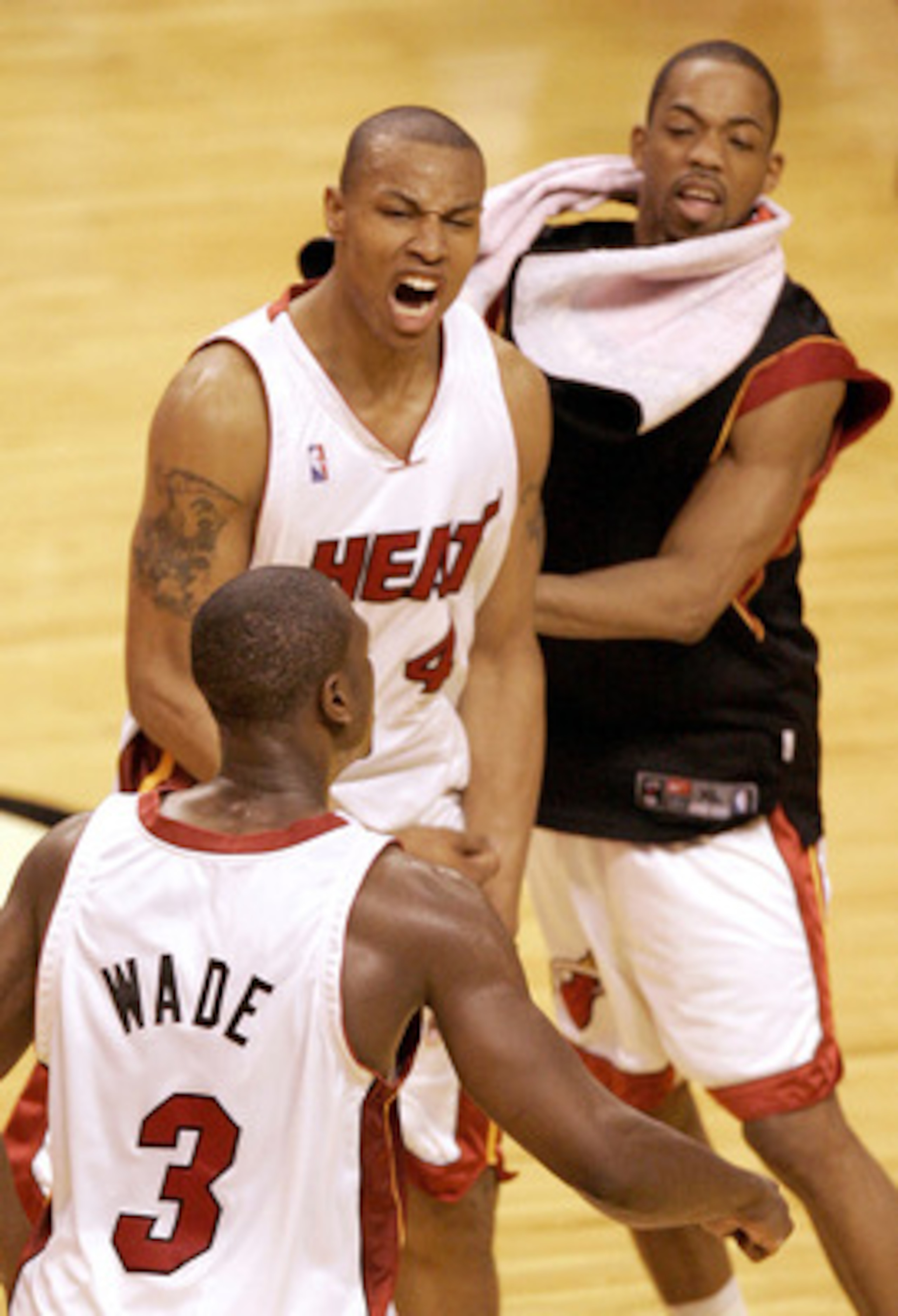 MIAMI - MAY 12:  Caron Butler #4 (C) of the Miami  Heat celebrates with teammates Dwyane Wade #3 (L) and Rafer Alston #11 the Heat's 100-88 win over the Indiana Pacers in Game Four of the Eastern Conference Semifinals during the 2004 NBA Playoffs May 12, 