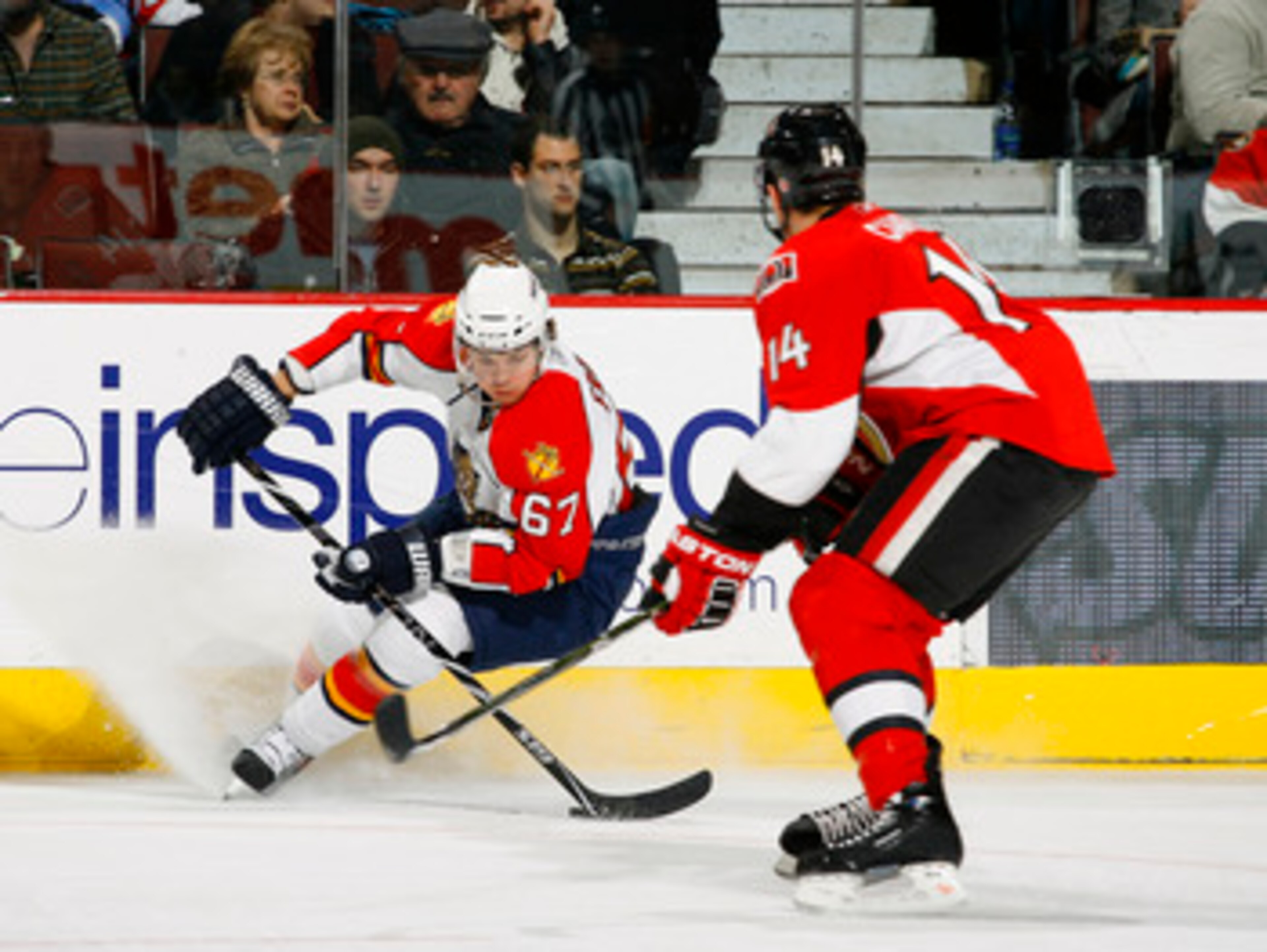 OTTAWA, ON - JANUARY 9:  Michael Frolik #67 of the Florida Panthers stops hard along the far boards with the puck while being watched by Chris Campoli #14 of the Ottawa Senators in a game at Scotiabank Place on January 9, 2010 in Ottawa, Canada.  (Photo b