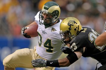 DENVER - AUGUST 31:  Running back Kyle Bell #34 of the Colorado State University Rams rushes and is tackled by Jalil Brown #23 of the University of Colorado Buffaloes at Invesco Field at Mile High on August 31, 2008 in Denver, Colorado. Colorado defeated 