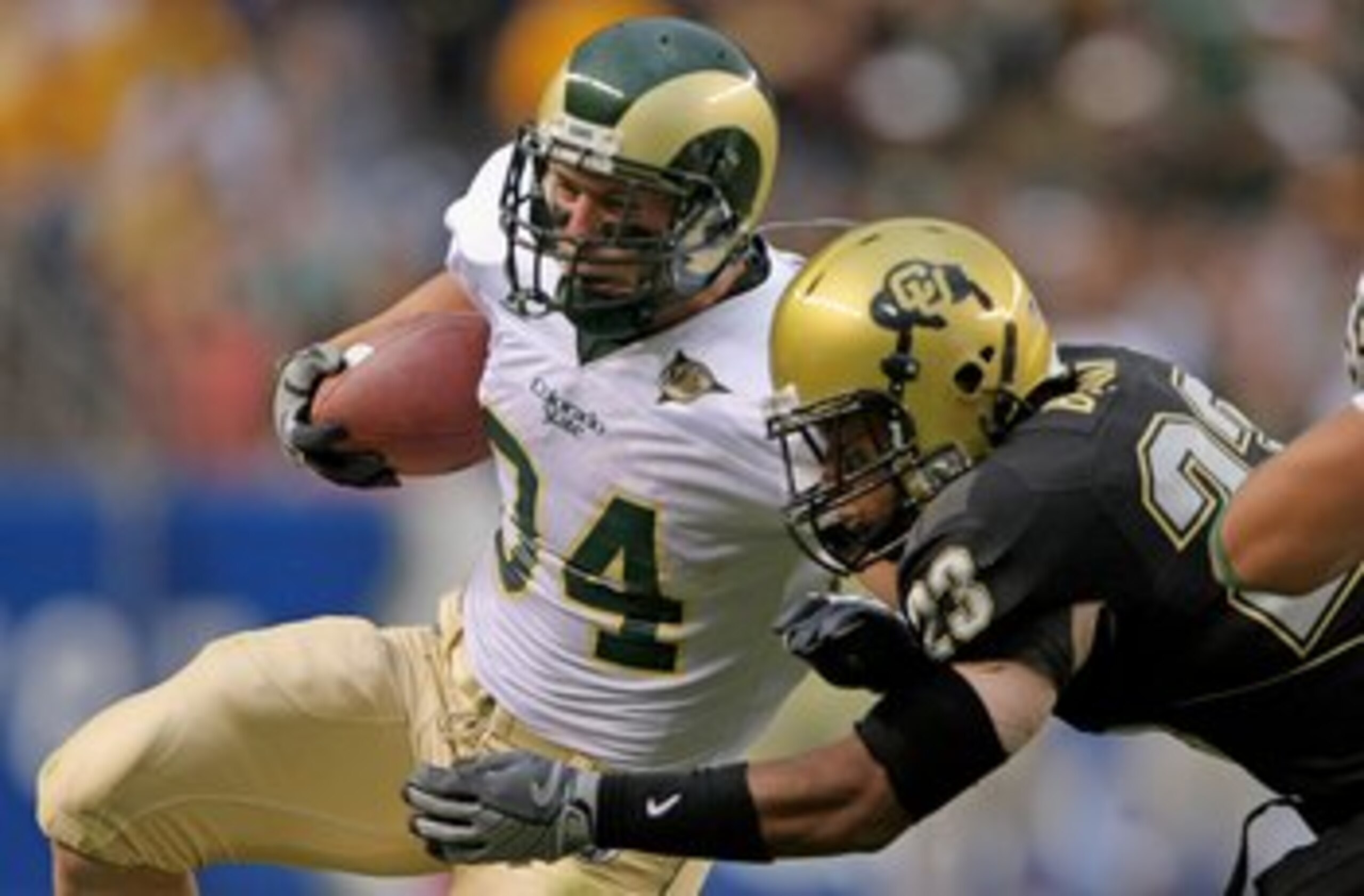 DENVER - AUGUST 31:  Running back Kyle Bell #34 of the Colorado State University Rams rushes and is tackled by Jalil Brown #23 of the University of Colorado Buffaloes at Invesco Field at Mile High on August 31, 2008 in Denver, Colorado. Colorado defeated 
