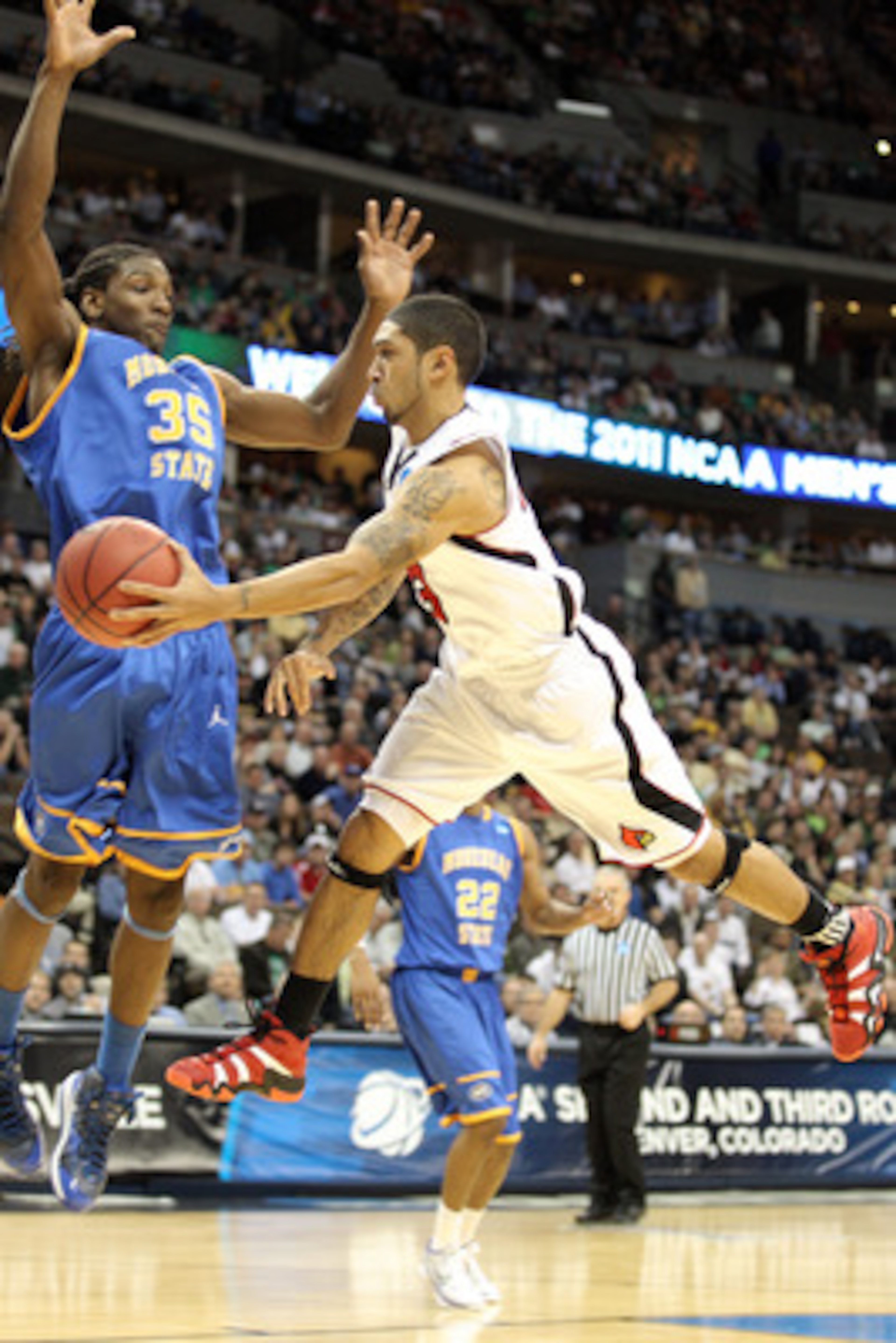 DENVER, CO - MARCH 17: Peyton Siva #3 of the Louisville Cardinals passes the ball against Kenneth Faried #35 of the Morehead State Eagles during the second round of the 2011 NCAA men's basketball tournament at Pepsi Center on March 17, 2011 in Denver, Co DENVER, CO - MARCH 17: Peyton Siva #3 of the Louisville Cardinals passes the ball against Kenneth Faried #35 of the Morehead State Eagles during the second round of the 2011 NCAA men's basketball tournament at Pepsi Center on March 17, 2011 in Denver, Co
