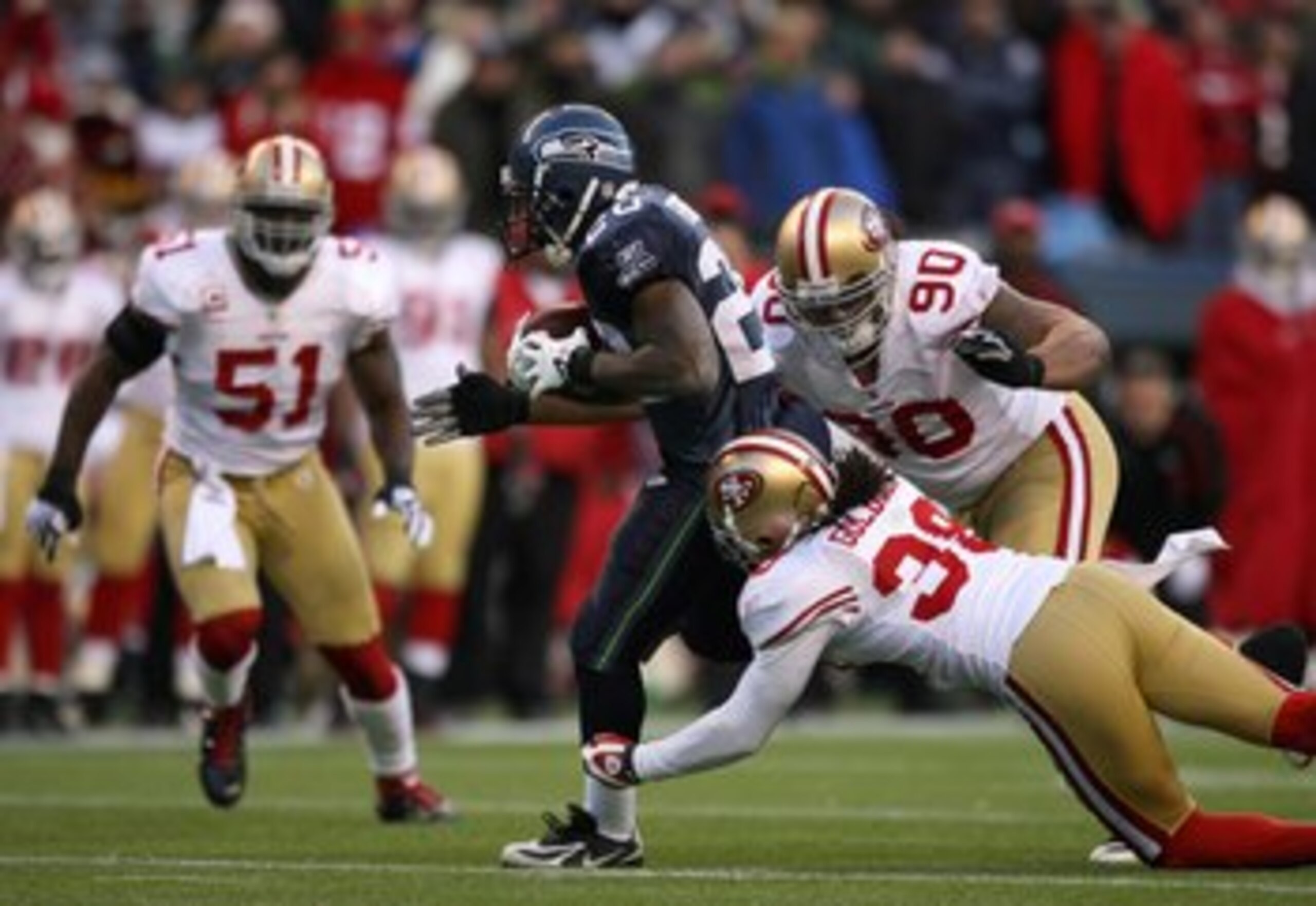 SEATTLE - DECEMBER 6:  Dashon Goldson #38 and Isaac Sopoaga #90 of the San Francisco 49ers gang tackle Justin Forsett #20 of the Seattle Seahawks during their NFL game on December 6, 2009 at Qwest Field in Seattle, Washington. The Seahawks defeated the 49
