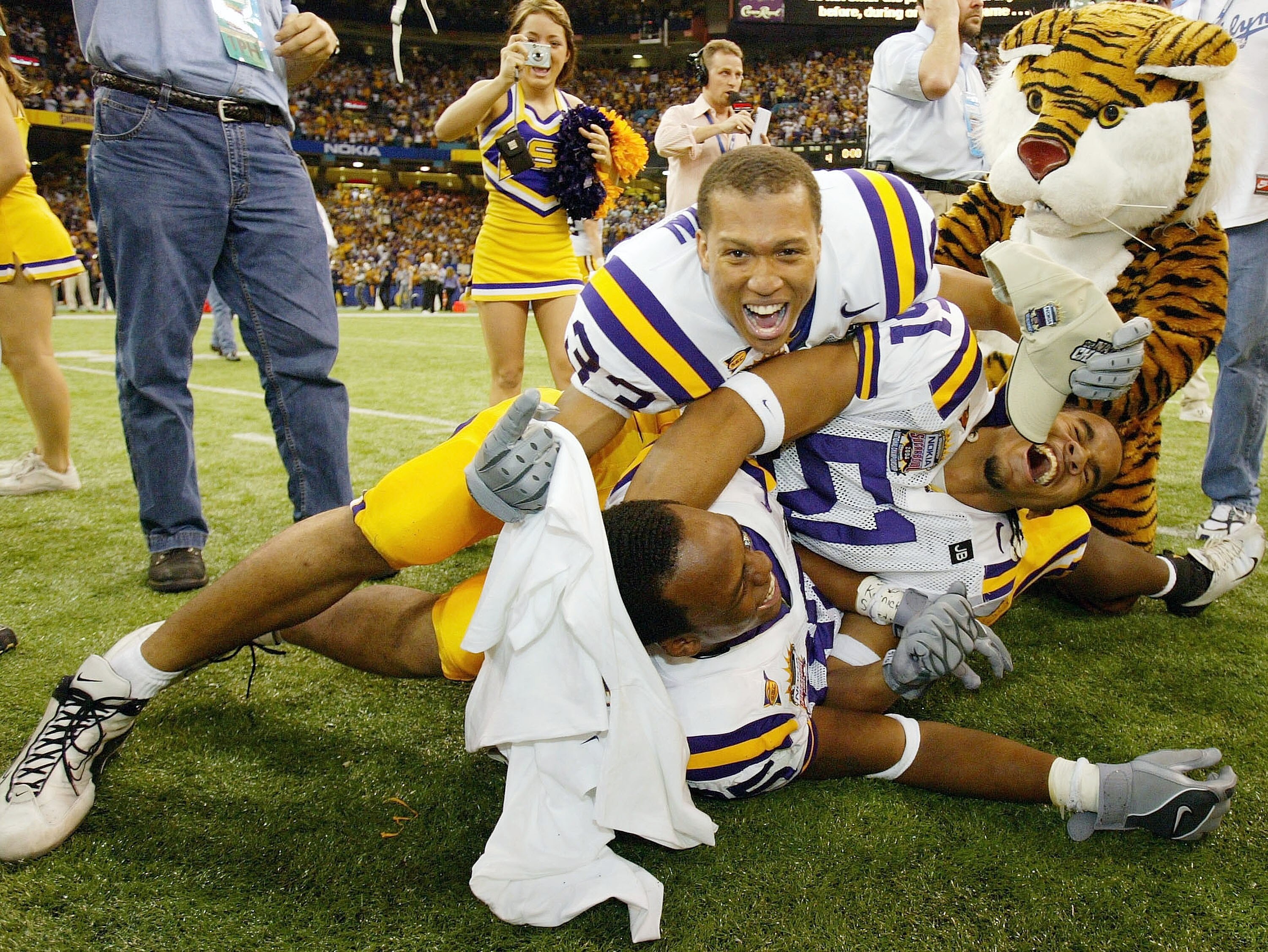 NEW ORLEANS - JANUARY 4:  Dominic Cooper #51, Jonathan Zenon #33 and Craig Davis #85 of LSU celebrate after defeating Oklahoma 21-14 to win the National Championship at the Nokia Sugar Bowl on January 4, 2004 at the Louisiana Superdome in New Orleans, Lou