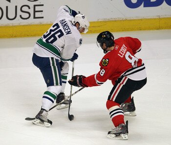 CHICAGO, IL - APRIL 19: Jannik Hansen #36 of the Vancouver Canucks controls the puck under pressure from Nick Leddy #8 of the Chicago Blackhawks in Game Four of the Western Conference Quarterfinals during the 2011 NHL Stanley Cup Playoffs at the United Ce