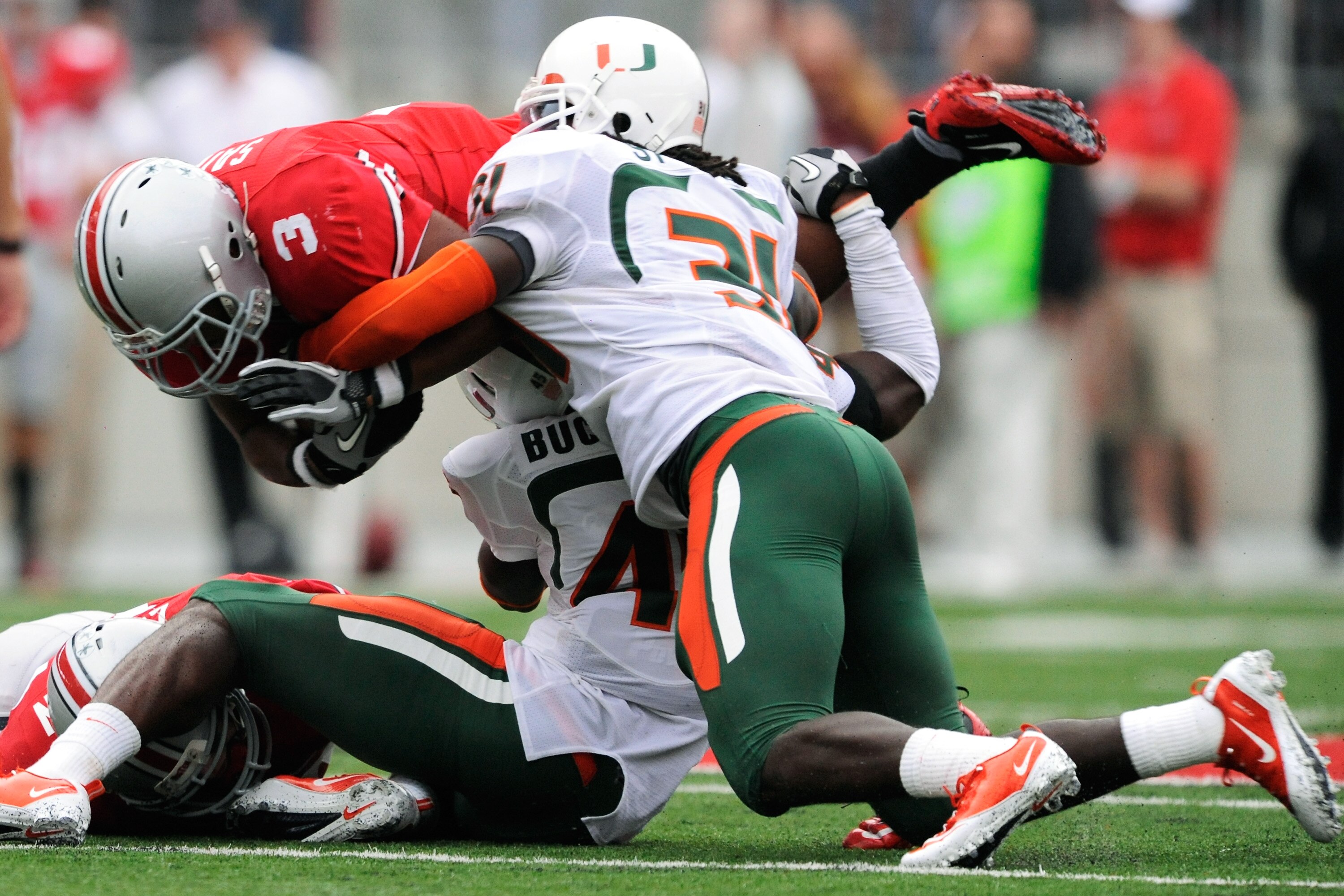 COLUMBUS, OH - SEPTEMBER 11:  Ramon Buchanan #45 of the Miami Hurricanes and Sean Spence #31 of the Hurricanes bring down Brandon Saine #3 of the Ohio State Buckeyes at Ohio Stadium on September 11, 2010 in Columbus, Ohio.  (Photo by Jamie Sabau/Getty Ima