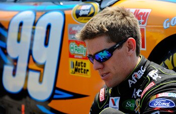 KANSAS CITY, KS - JUNE 05:  Carl Edwards, driver of the #99 Aflac Ford, puts his shoes on on the grid during the NASCAR Sprint Cup Series STP 400 at Kansas Speedway on June 5, 2011 in Kansas City, Kansas.  (Photo by Jared C. Tilton/Getty Images for NASCAR