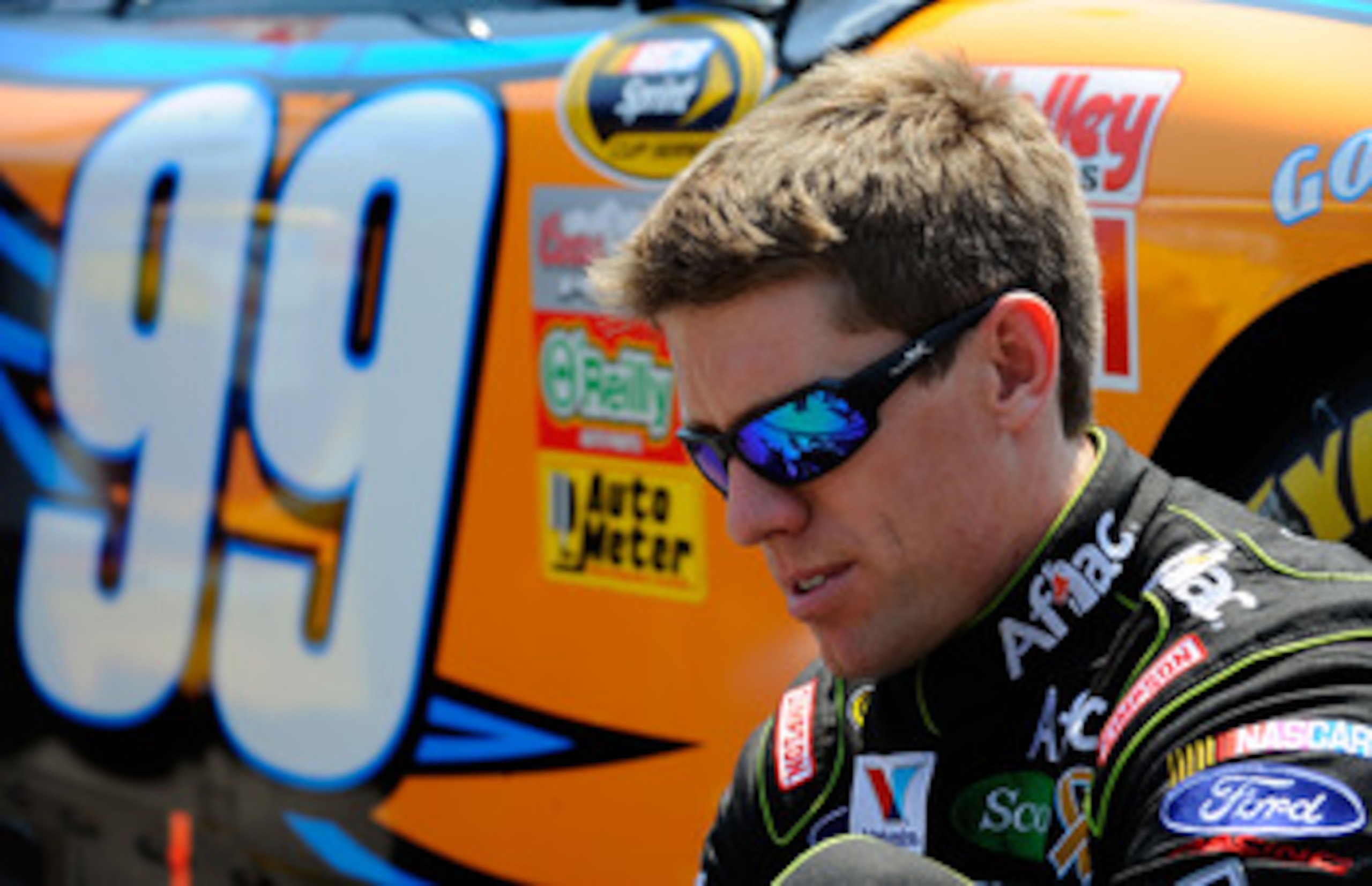 KANSAS CITY, KS - JUNE 05:  Carl Edwards, driver of the #99 Aflac Ford, puts his shoes on on the grid during the NASCAR Sprint Cup Series STP 400 at Kansas Speedway on June 5, 2011 in Kansas City, Kansas.  (Photo by Jared C. Tilton/Getty Images for NASCAR
