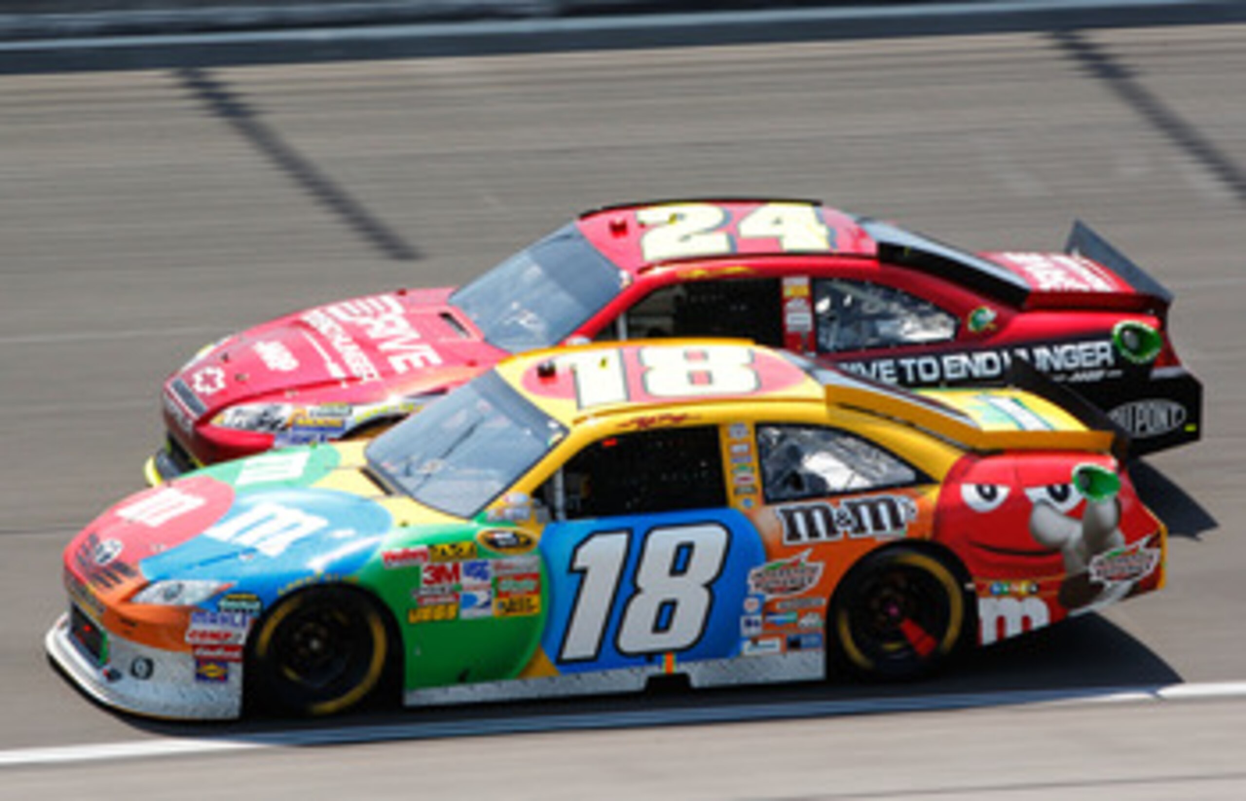 KANSAS CITY, KS - JUNE 05:  Kyle Busch, driver of the #18 M&M's Toyota, races Jeff Gordon, driver of the #24 Drive to End Hunger Chevrolet, during the NASCAR Sprint Cup Series STP 400 at Kansas Speedway on June 5, 2011 in Kansas City, Kansas.  (Photo by G