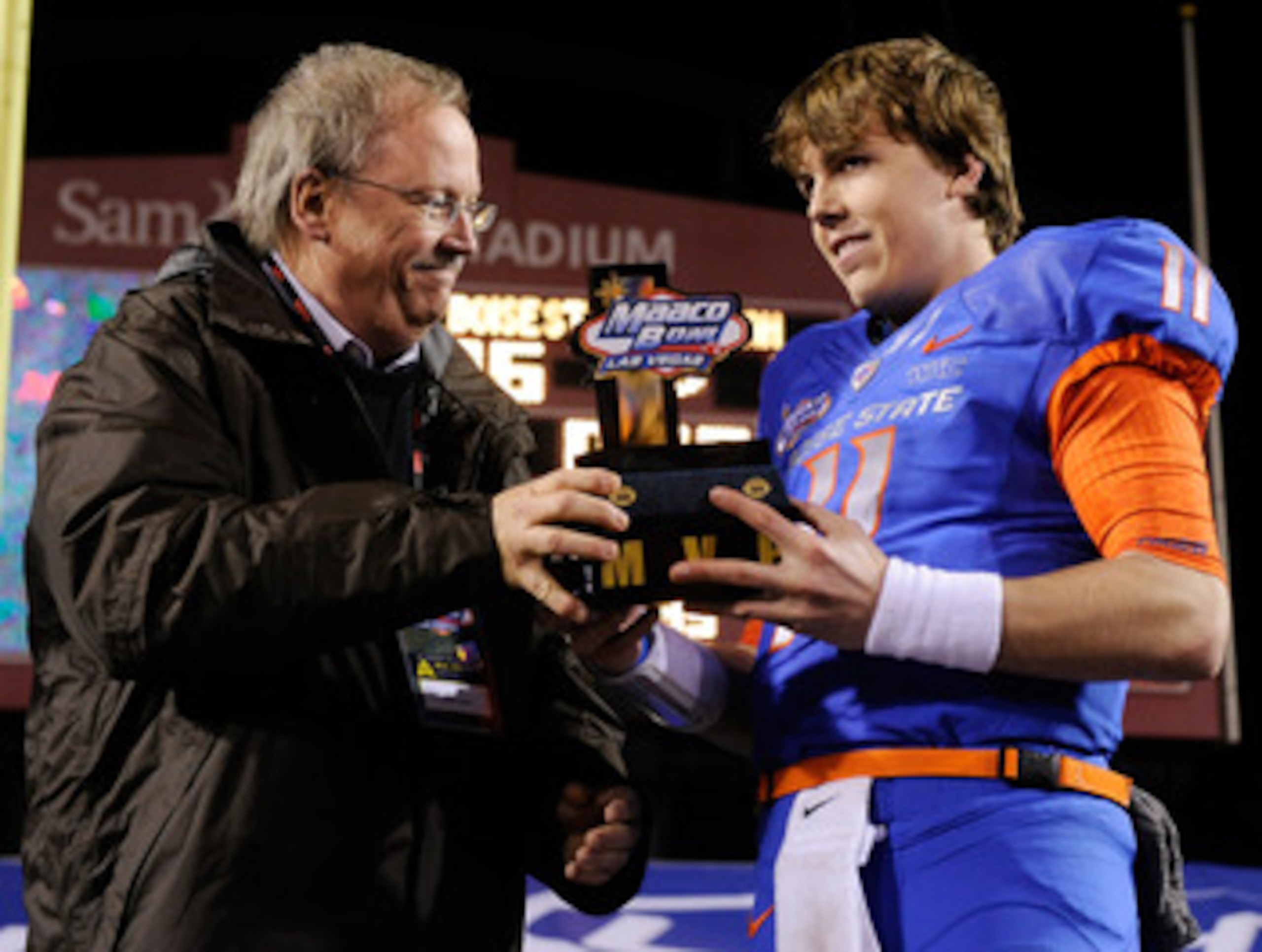 LAS VEGAS, NV - DECEMBER 22:  MAACO President Dave Lapps (L) gives the most valuable player trophy to quarterback Kellen Moore #11 of the Boise State Broncos after the team's 26-3 victory over the Utah Utes in the MAACO Bowl Las Vegas at Sam Boyd Stadium 