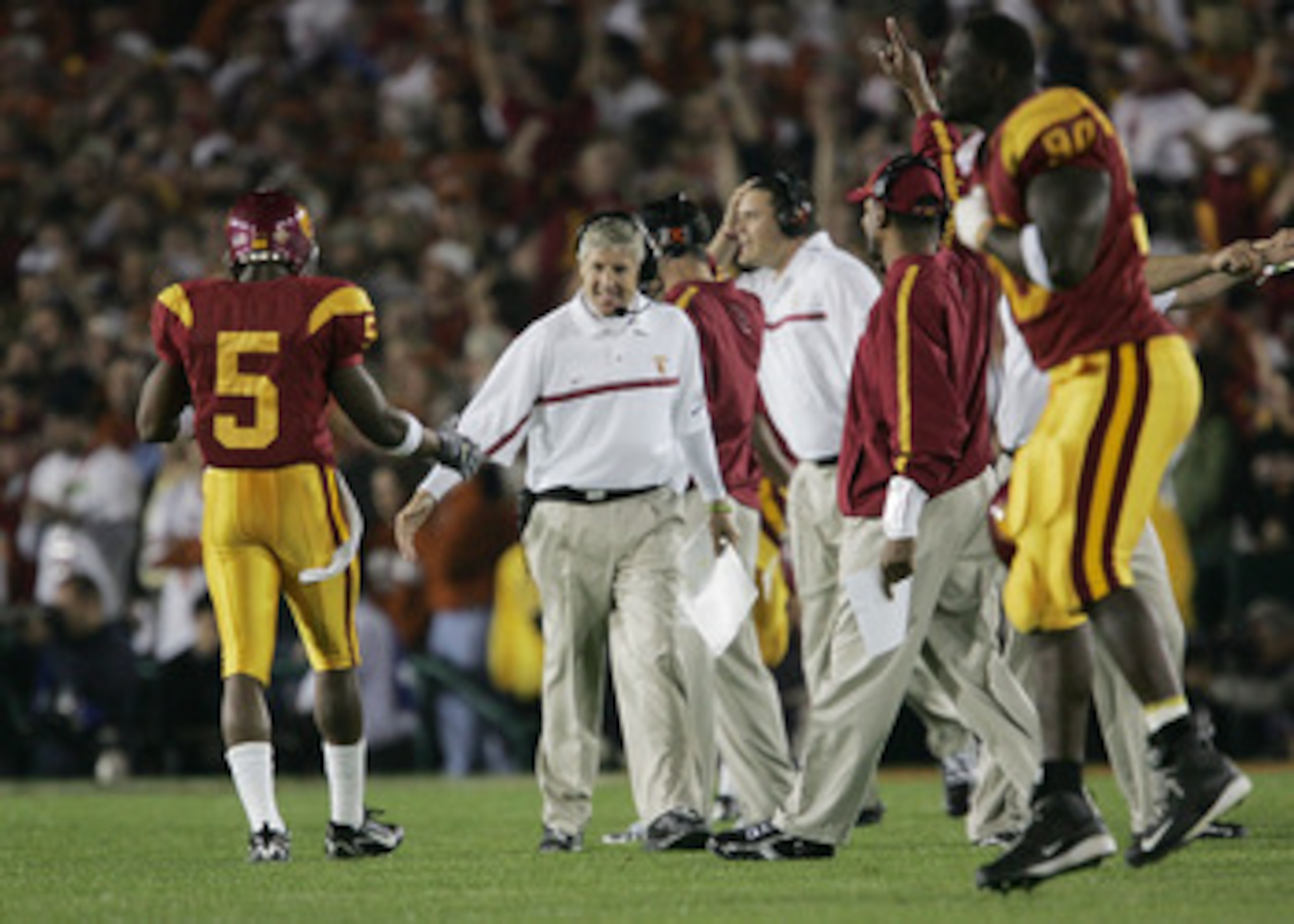 PASADENA, CA - JANUARY 04:  Head coach Pete Carroll of the USC Trojans congratulates running back Reggie Bush #5 after teammate LenDale White #21 scored on a 4-yard run against the Texas Longhorns in the first quarter during the BCS National Championship