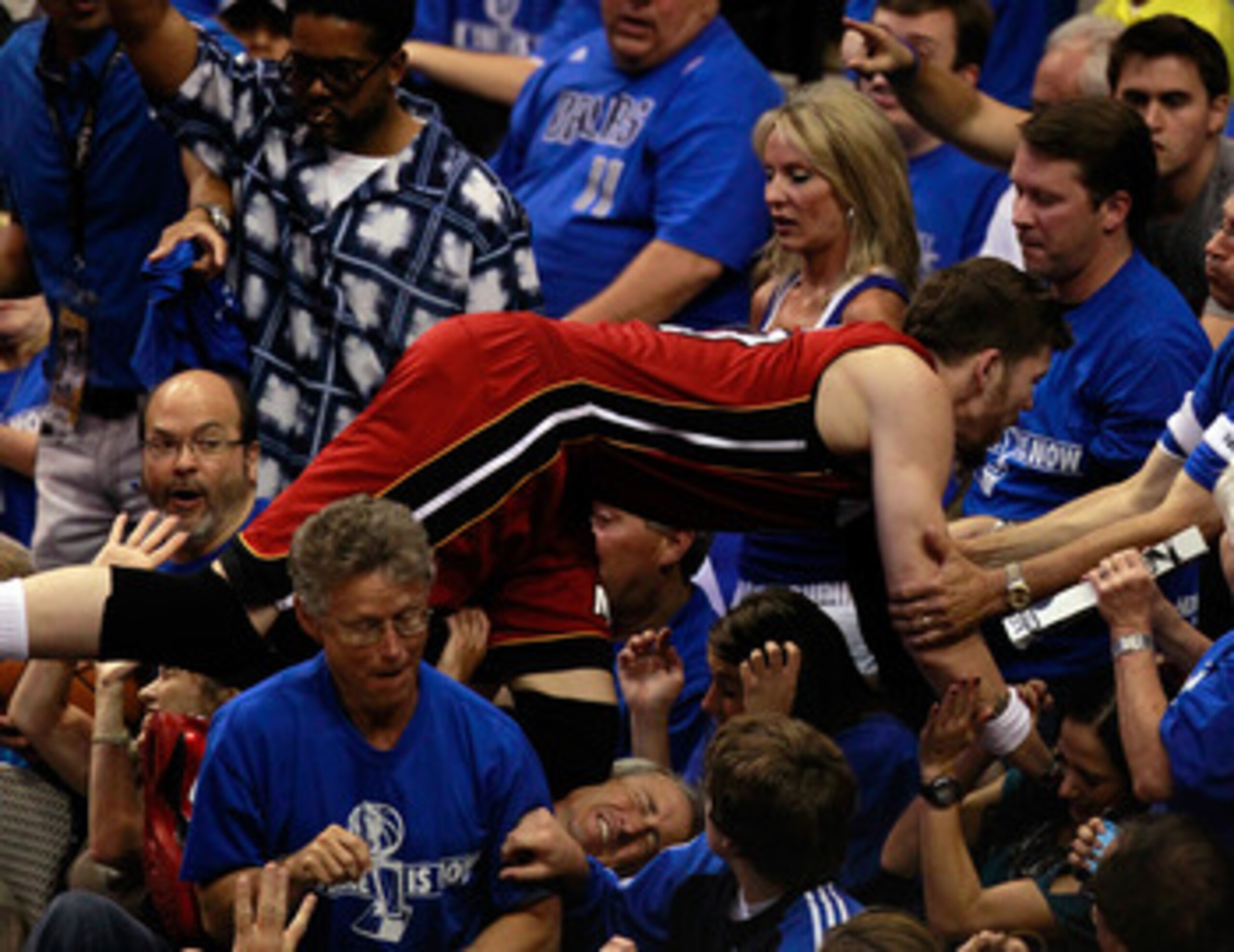 DALLAS, TX - JUNE 05:  Mike Miller #13 of the Miami Heat falls into the stands behind the basket in the second half while taking on the Dallas Mavericks in Game Three of the 2011 NBA Finals at American Airlines Center on June 5, 2011 in Dallas, Texas.  NO
