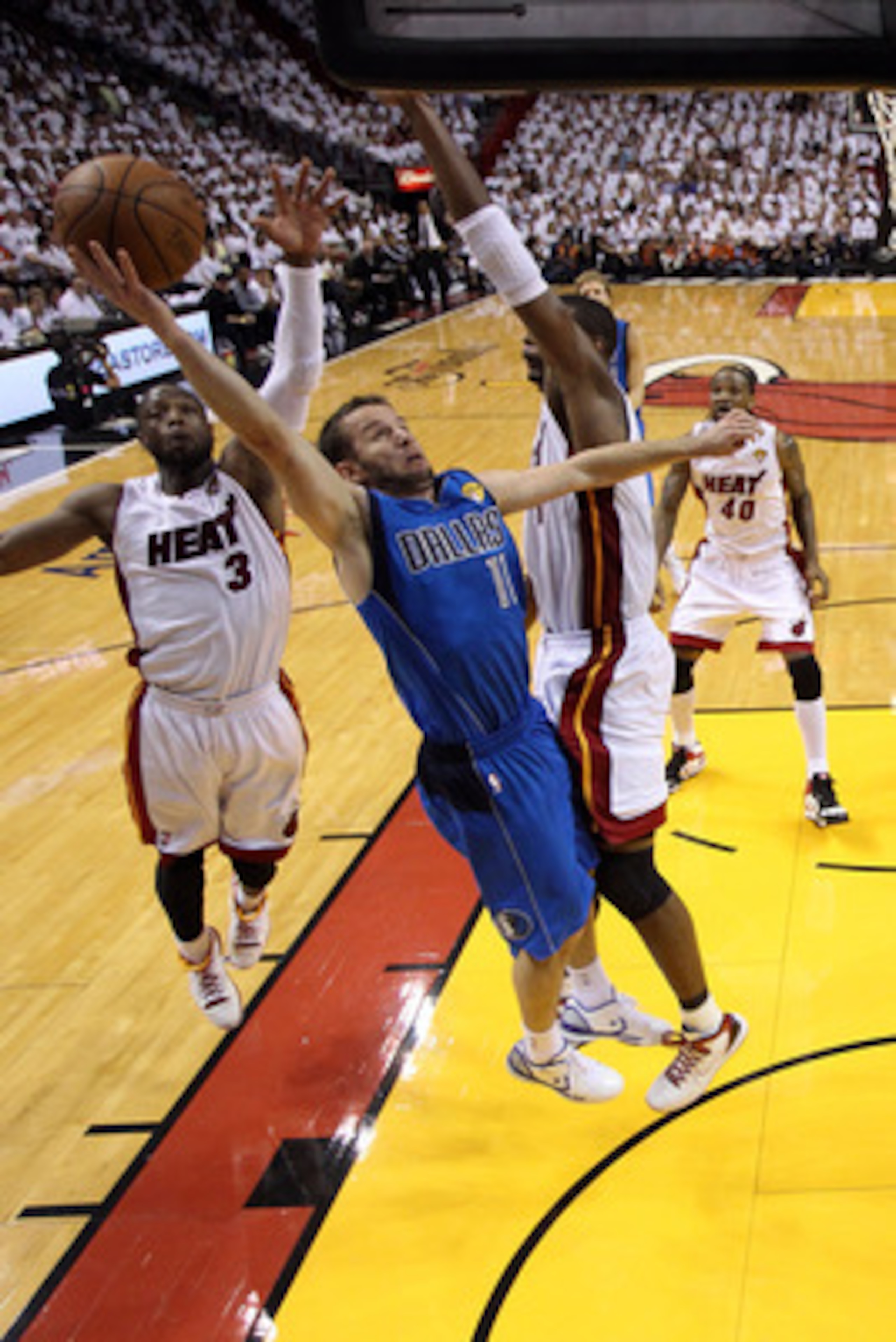 MIAMI, FL - JUNE 02:  Jose Juan Barea #11 of the Dallas Mavericks drives for a shot attempt against Chris Bosh #1 and Dwyane Wade #3 of the Miami Heat in Game Two of the 2011 NBA Finals at American Airlines Arena on June 2, 2011 in Miami, Florida. NOTE TO
