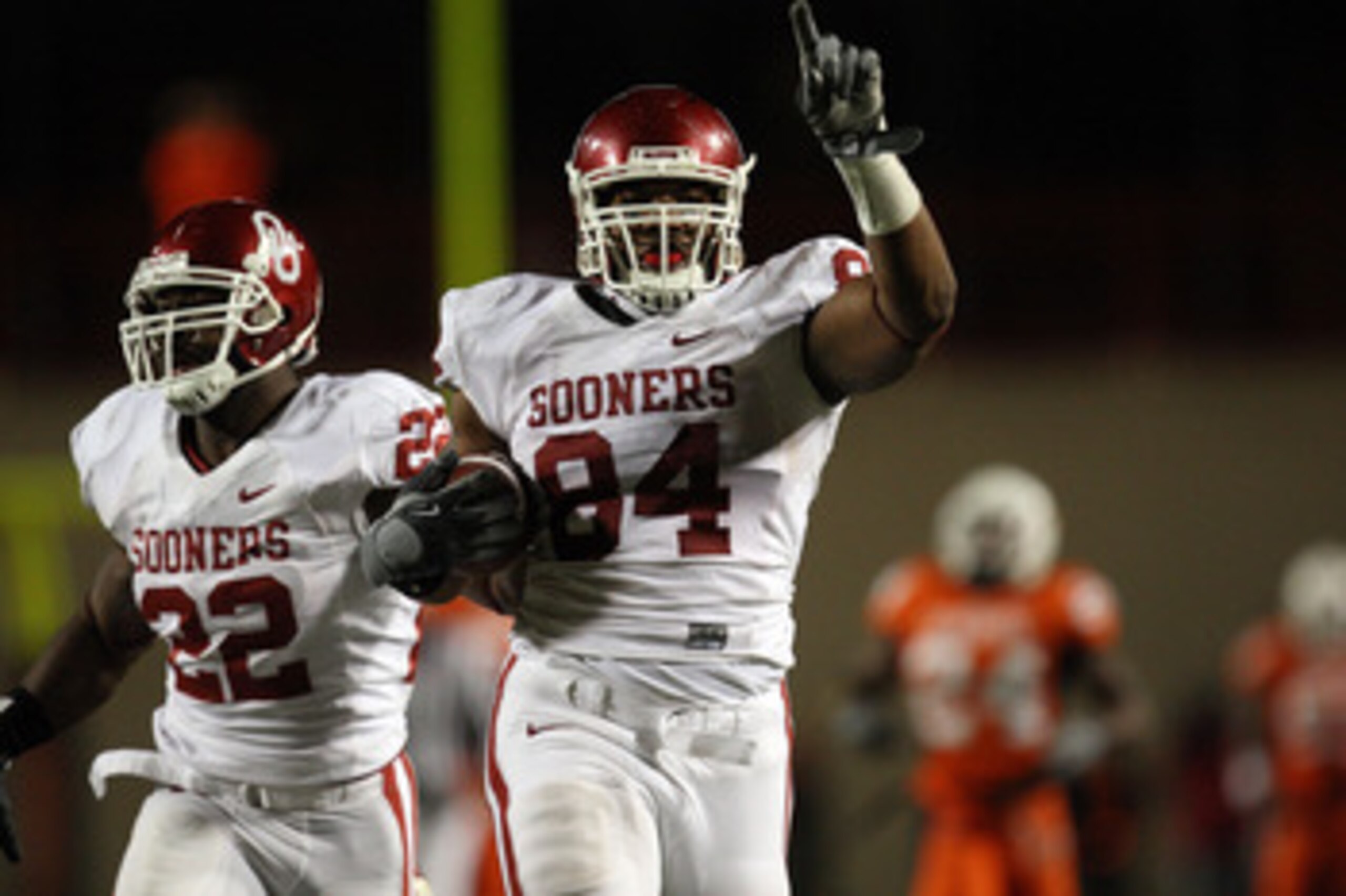 STILLWATER, OK - NOVEMBER 29:  Defensive end Frank Alexander #84 of the Oklahoma Sooners runs for a defensive two-point conversion with Keenan Clayton #22 against the Oklahoma State Cowboys at Boone Pickens Stadium on November 29, 2008 in Stillwater, Okla