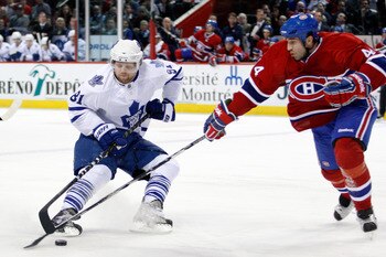 MONTREAL, CANADA - FEBRUARY 24:  Phil Kessel #81 of the Toronto Maple Leafs slides the puck past Roman Hamrlik #44 of the Montreal Canadiens during the NHL game at the Bell Centre on February 24, 2011 in Montreal, Quebec, Canada.  The Maple Leafs defeated