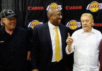 EL SEGUNDO, CA - MAY 31:  Mike Brown, (C) the new head coach for the Los Angeles Lakers, looks at team owner Jerry Buss (R) speaks while Jim Buss, vice president of player personnel, looks on after Brown's introductory news conference at the team's traini