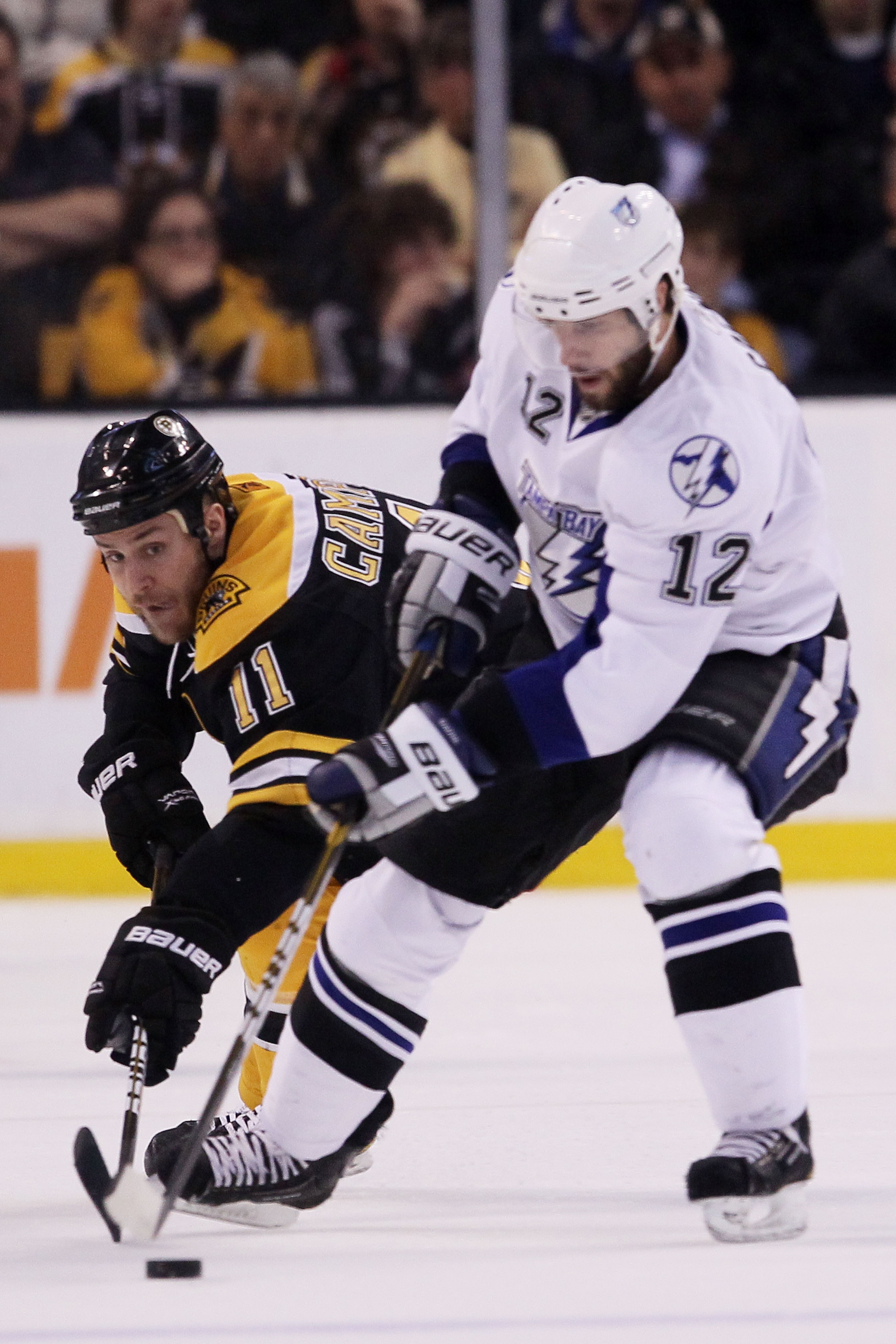 BOSTON, MA - MAY 23:  Gregory Campbell #11 of the Boston Bruins and Simon Gagne #12 of the Tampa Bay Lightning vie for the puck in Game Five of the Eastern Conference Finals during the 2011 NHL Stanley Cup Playoffs at TD Garden on May 23, 2011 in Boston,
