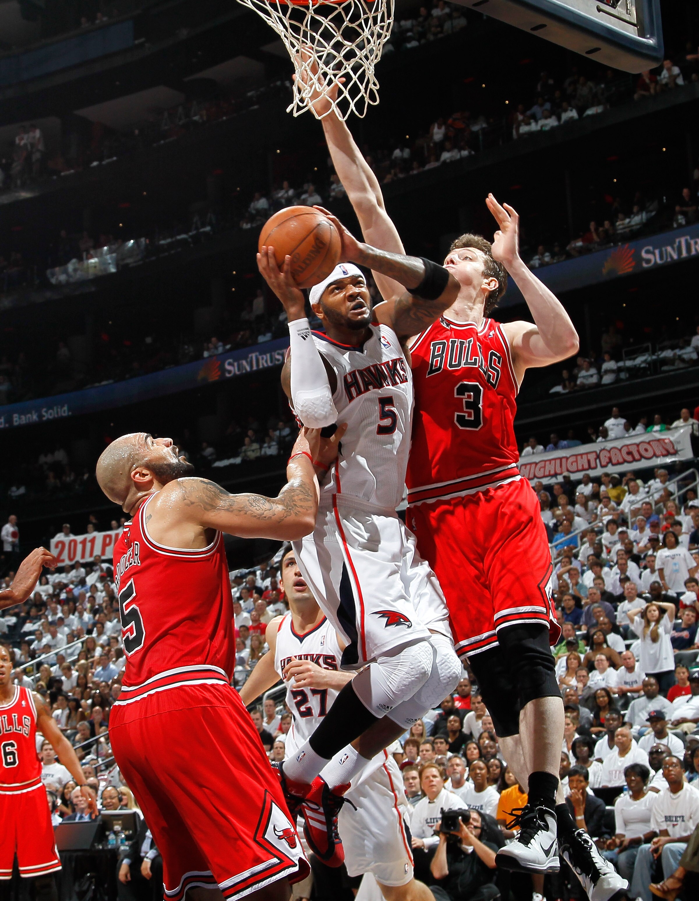 ATLANTA, GA - MAY 12:  Josh Smith #5 of the Atlanta Hawks drives against Carlos Boozer #5 and Omer Asik #3 of the Chicago Bulls in Game Six of the Eastern Conference Semifinals in the 2011 NBA Playoffs at Phillips Arena on May 12, 2011 in Atlanta, Georgia