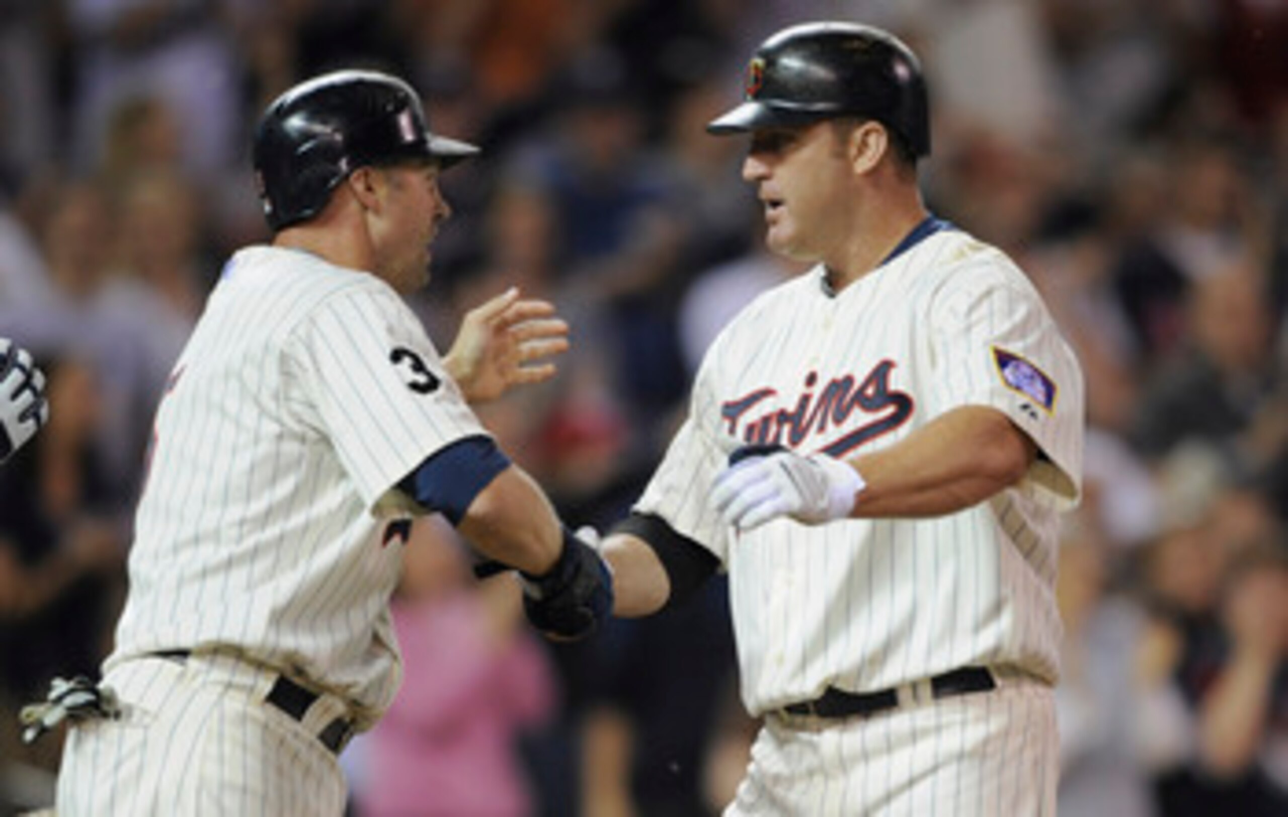 MINNEAPOLIS, MN - MAY 23: Michael Cuddyer #5 and Jim Thome #25 of the Minnesota Twins celebrate Thome's second two-run home run of the game against the Seattle Mariners in the seventh inning of their game on May 16, 2011 at Target Field in Minneapolis, Mi