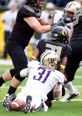 EUGENE, OR - NOVEMBER 6: Running back LaMichael James #21 of the Oregon Ducks fumbles the ball as he is hit by linebacker Cort Dennison #31 of the Washington Huskies in the second quarter of the game at Autzen Stadium on November 6, 2010 in Eugene, Oregon
