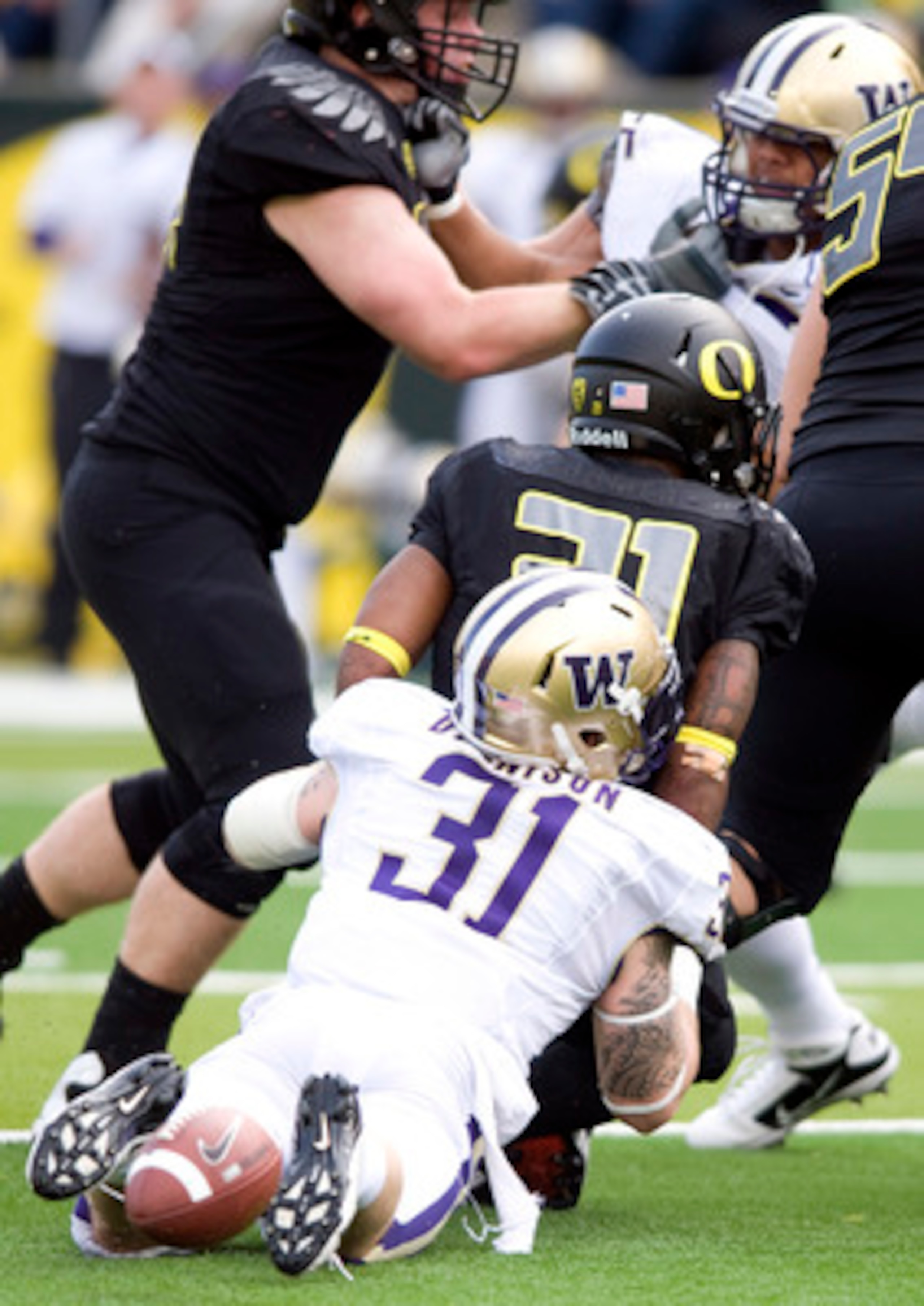 EUGENE, OR - NOVEMBER 6: Running back LaMichael James #21 of the Oregon Ducks fumbles the ball as he is hit by linebacker Cort Dennison #31 of the Washington Huskies in the second quarter of the game at Autzen Stadium on November 6, 2010 in Eugene, Oregon