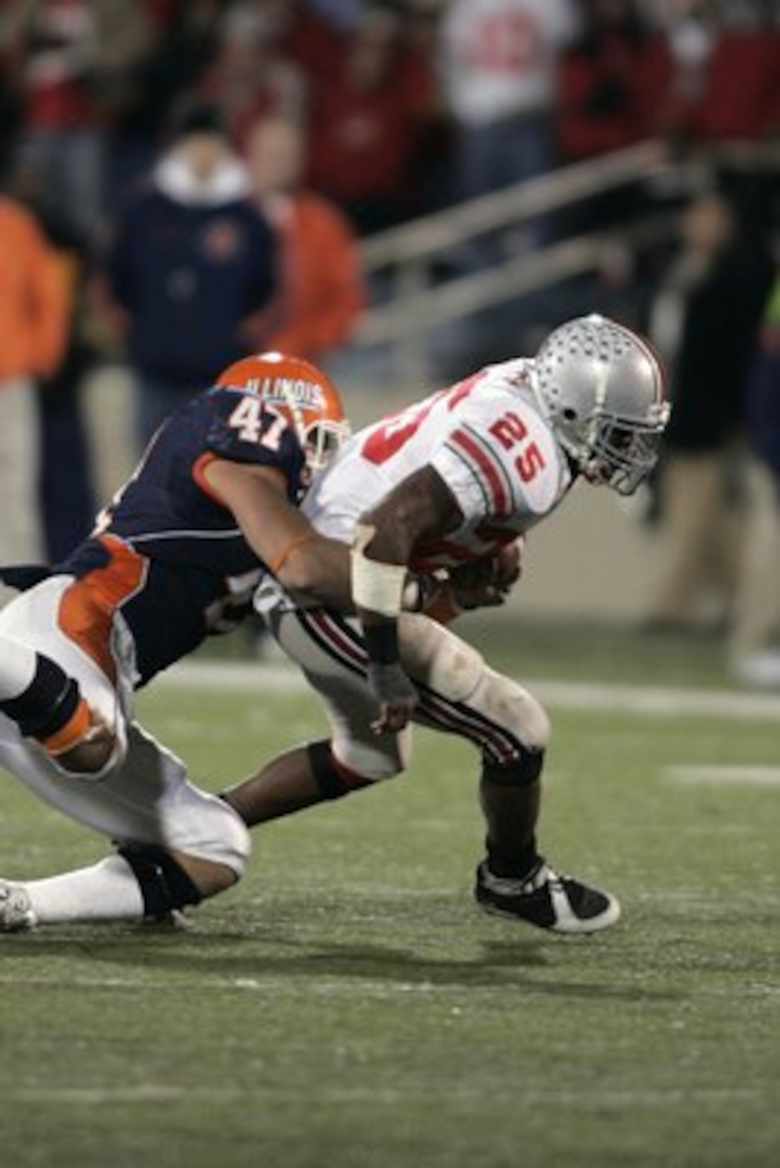 CHAMPAIGN, IL - NOVEMBER 4:  Running back Antonio Pittman #25 of the Ohio State Buckeyes runs with the football as he is tackled by J Leman #47 of the Illinois Fighting Illini in the first half at Memorial Stadium November 4, 2006 in Champaign, Illinois. 