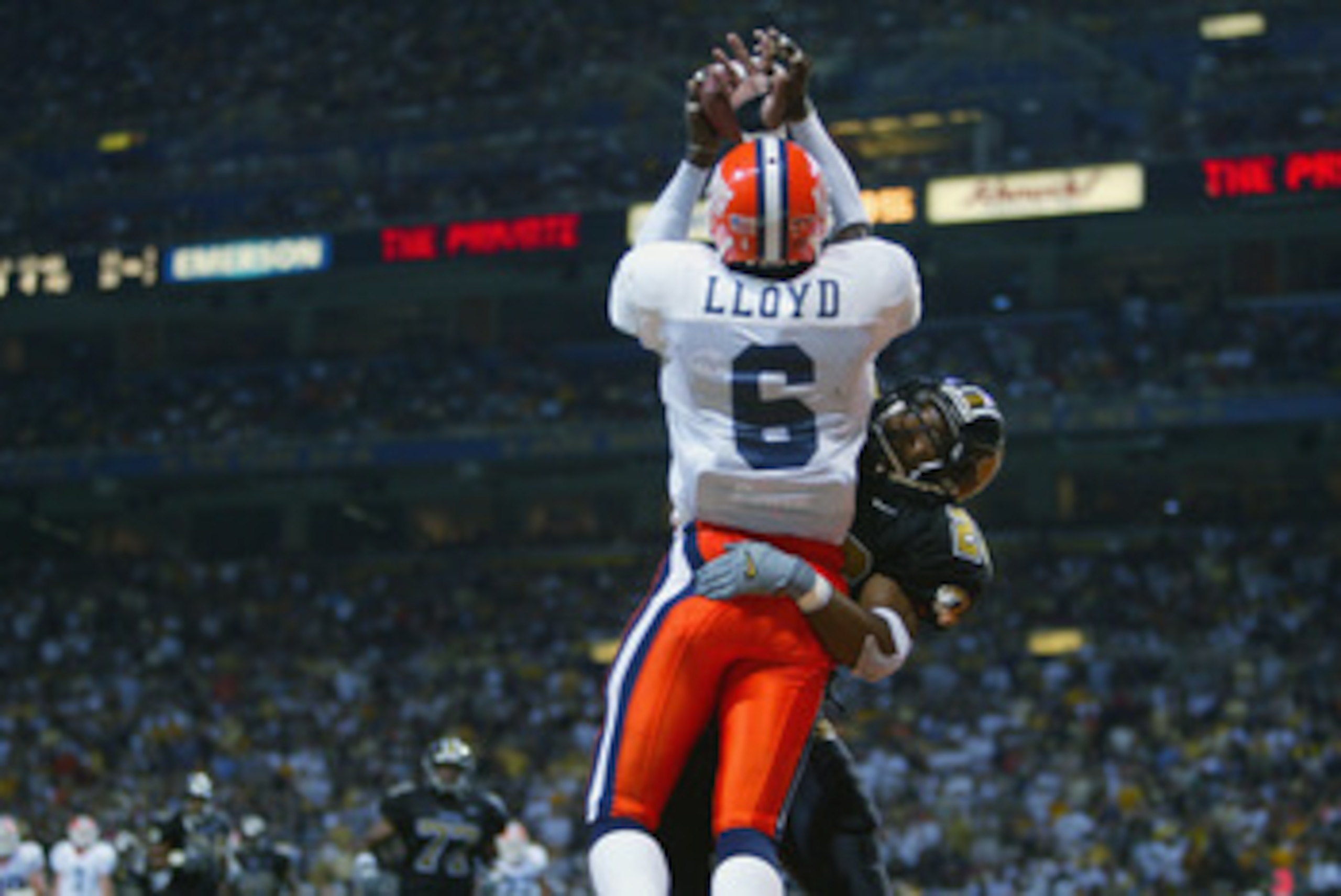 ST. LOUIS - AUGUST 31:  Brandon Lloyd #6 of Illinois is unable to hang on to the ball as Michael Harden #26 of Missouri defends in the second half on August 31, 2002 at the Edward Jones Dome in St. Louis, Missouri.  Missouri defeated Illinois 33-20.  (Pho