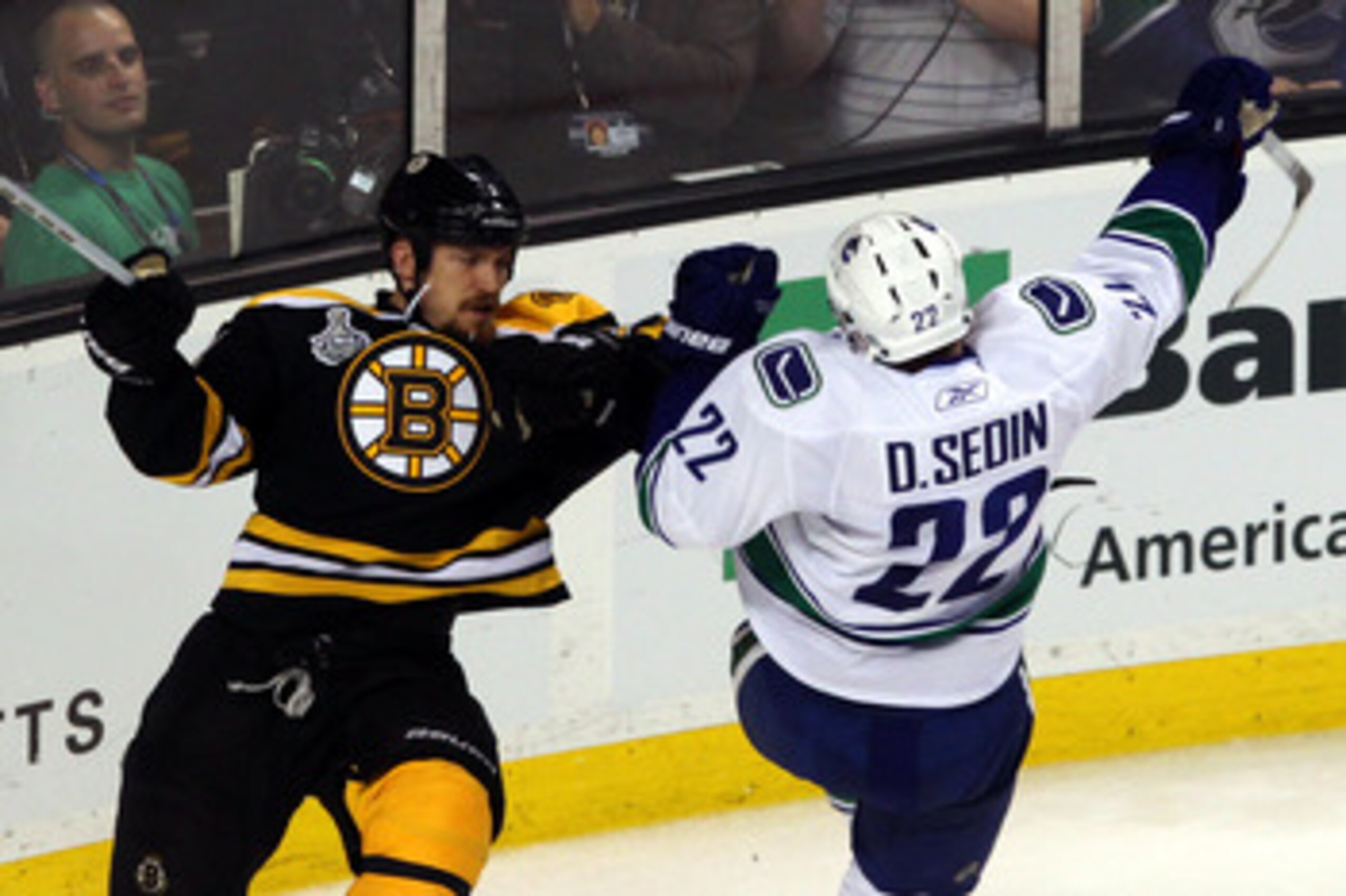 BOSTON, MA - JUNE 06:  Andrew Ference #21 of the Boston Bruins checks Daniel Sedin #22 of the Vancouver Canucks during Game Three of the 2011 NHL Stanley Cup Final at TD Garden on June 6, 2011 in Boston, Massachusetts.  (Photo by Bruce Bennett/Getty Image