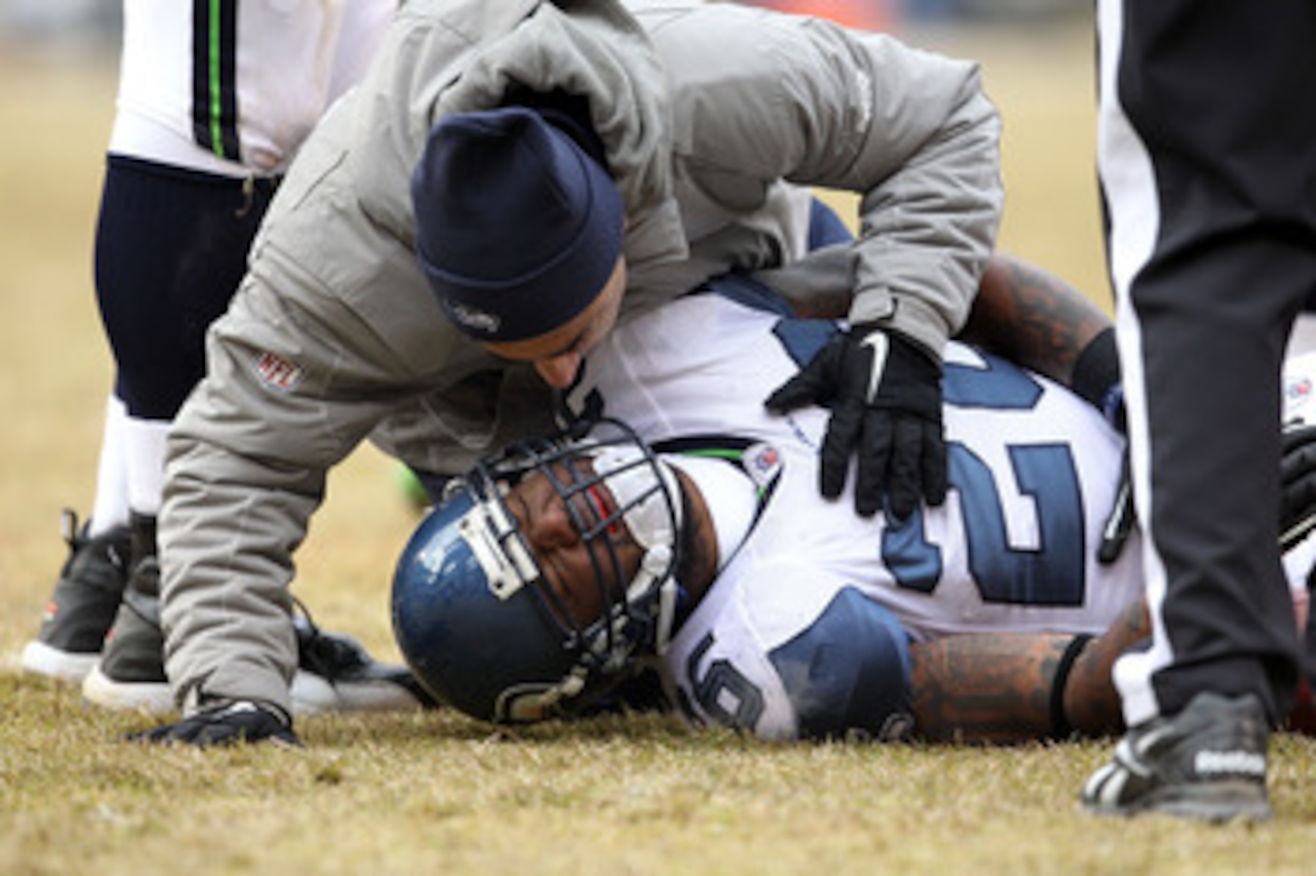 CHICAGO, IL - JANUARY 16:  Michael Robinson #26 of the Seattle Seahawks is checked on by a trainer after an injury in the second half against the Chicago Bears in the 2011 NFC divisional playoff game at Soldier Field on January 16, 2011 in Chicago, Illino