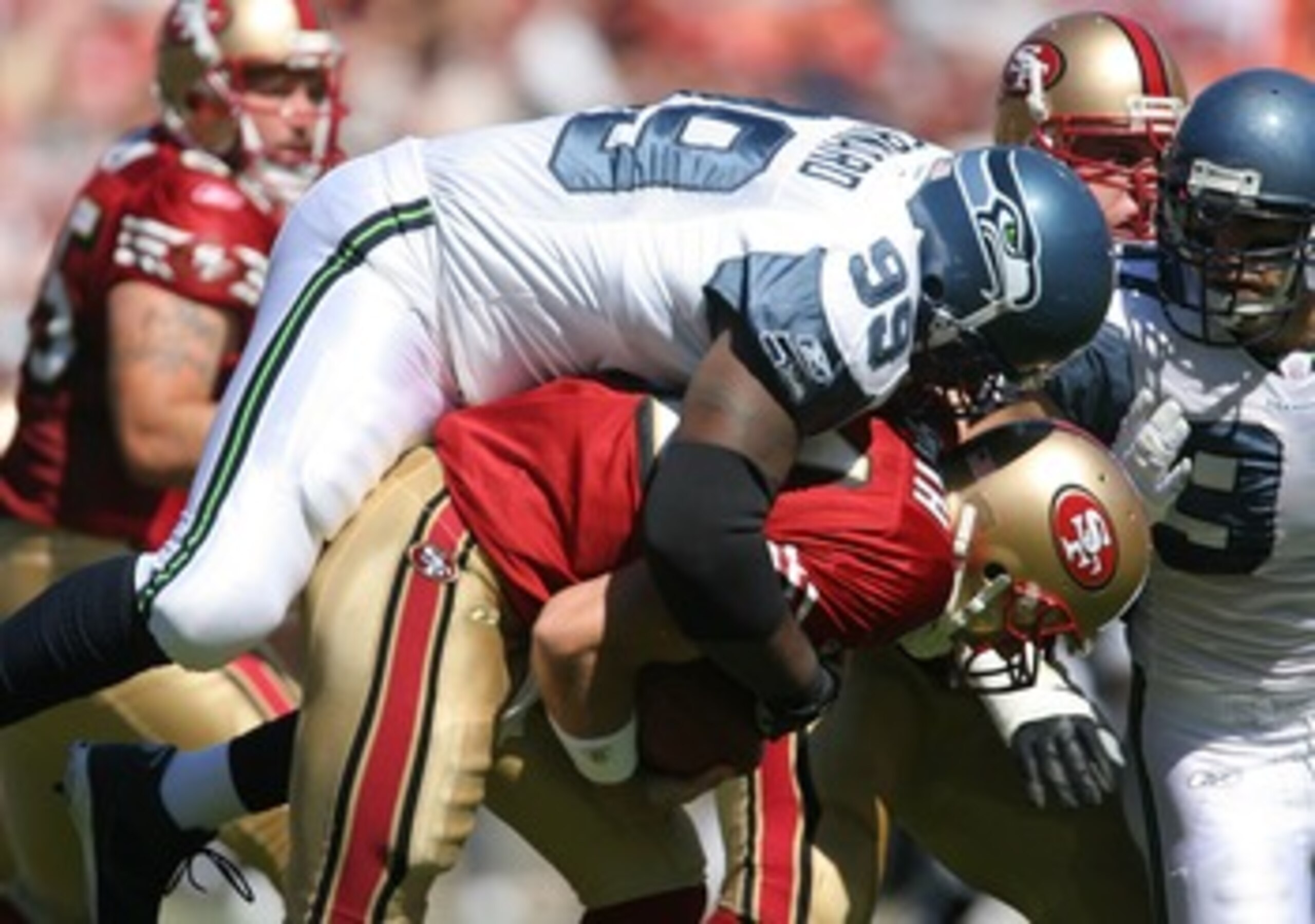 SAN FRANCISCO - SEPTEMBER 30:  Quarterback Alex Smith #11 of the San Francisco 49ers is sacked by defensive lineman Rocky Bernard #99 of the Seattle Seahawks during the first quarter at Monster Park September 30, 2007 in San Francisco, California.  (Photo