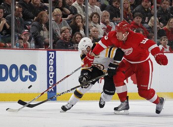 DETROIT, MI - FEBRUARY 13:  David Krejci #46 of the Boston Bruins battles for the puck with Johan Franzen #93 of the of the Detroit Red Wings on February 13, 2011 at Joe Lewis Arena in Detroit, Michigan. Detroit won the game 4-2.  (Photo by Gregory Shamus