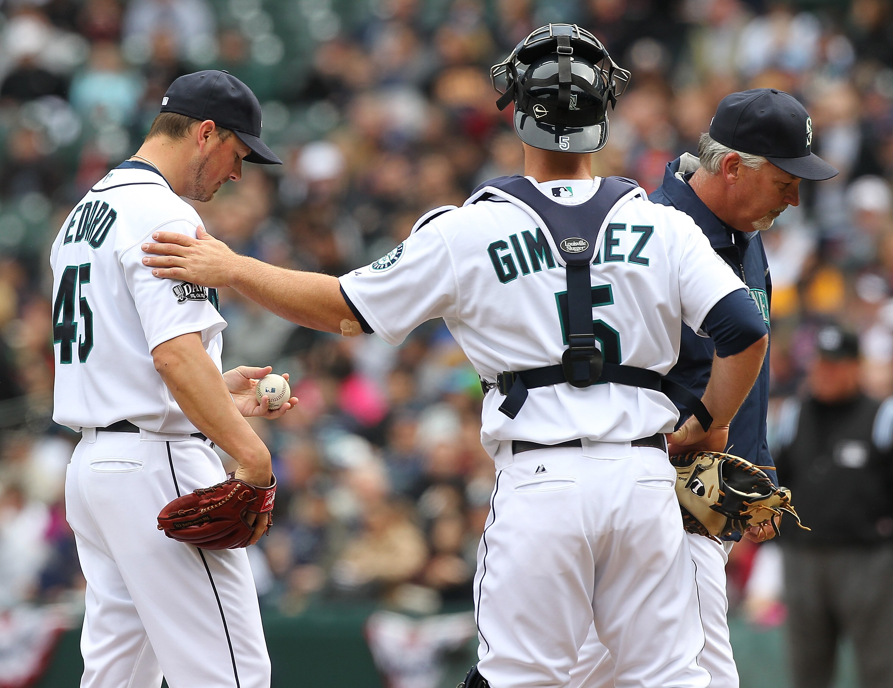 SEATTLE - APRIL 10:  Starting pitcher Erik Bedard #45 of the Seattle Mariners gets a pat on the shoulder from catcher Chris Gimenez #5 after a visit from pitching coach Carl Willis #48 during the game against the Cleveland Indians at Safeco Field on April