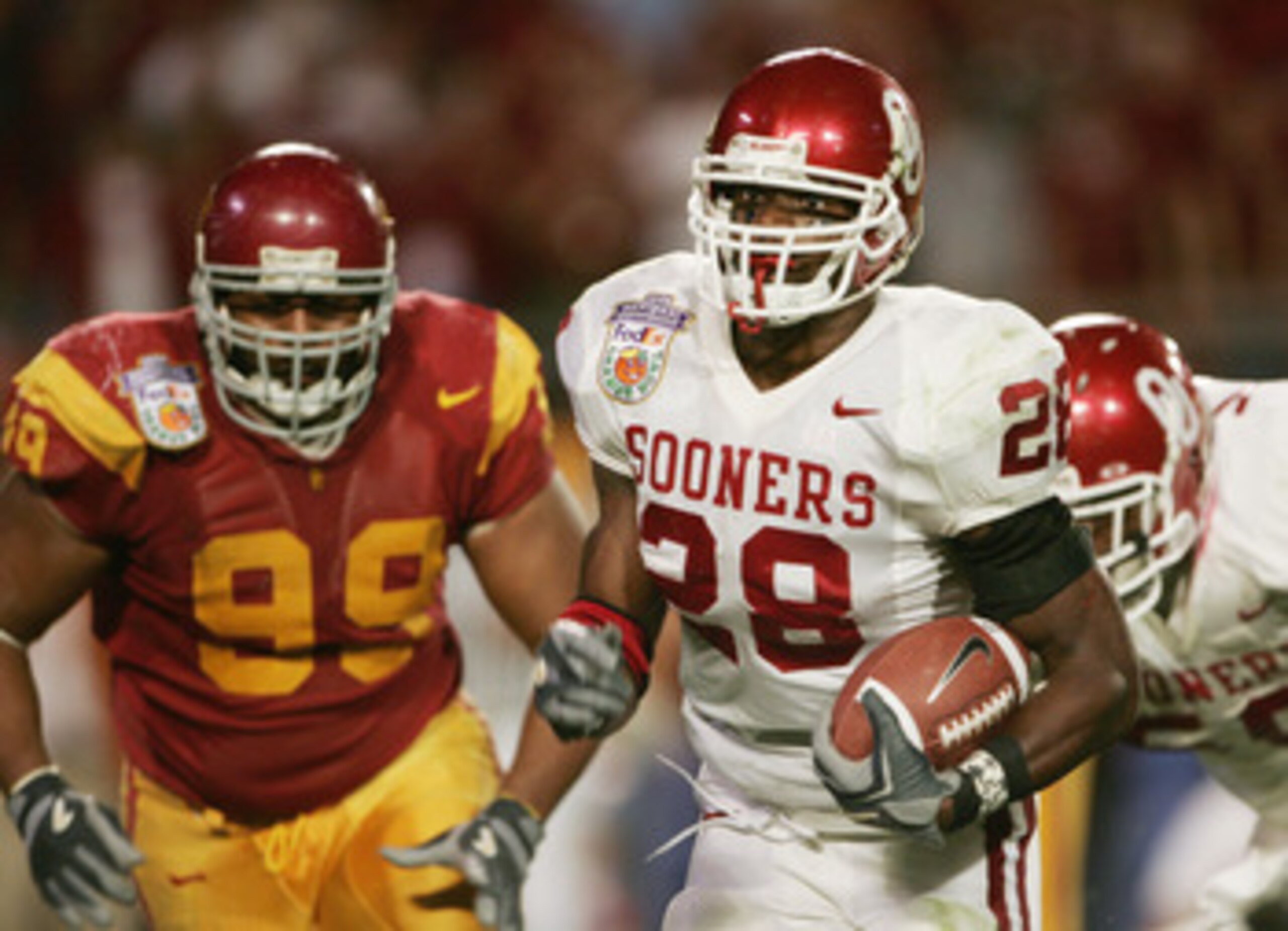 MIAMI - JANUARY 4:  Running back Adrian Peterson #28 of the Oklahoma Sooners runs upfield against defensive tackle Mike Patterson #99 of the USC Trojans in the 2005 FedEx Orange Bowl National Championship on January 4, 2005 at Pro Player Stadium in Miami,