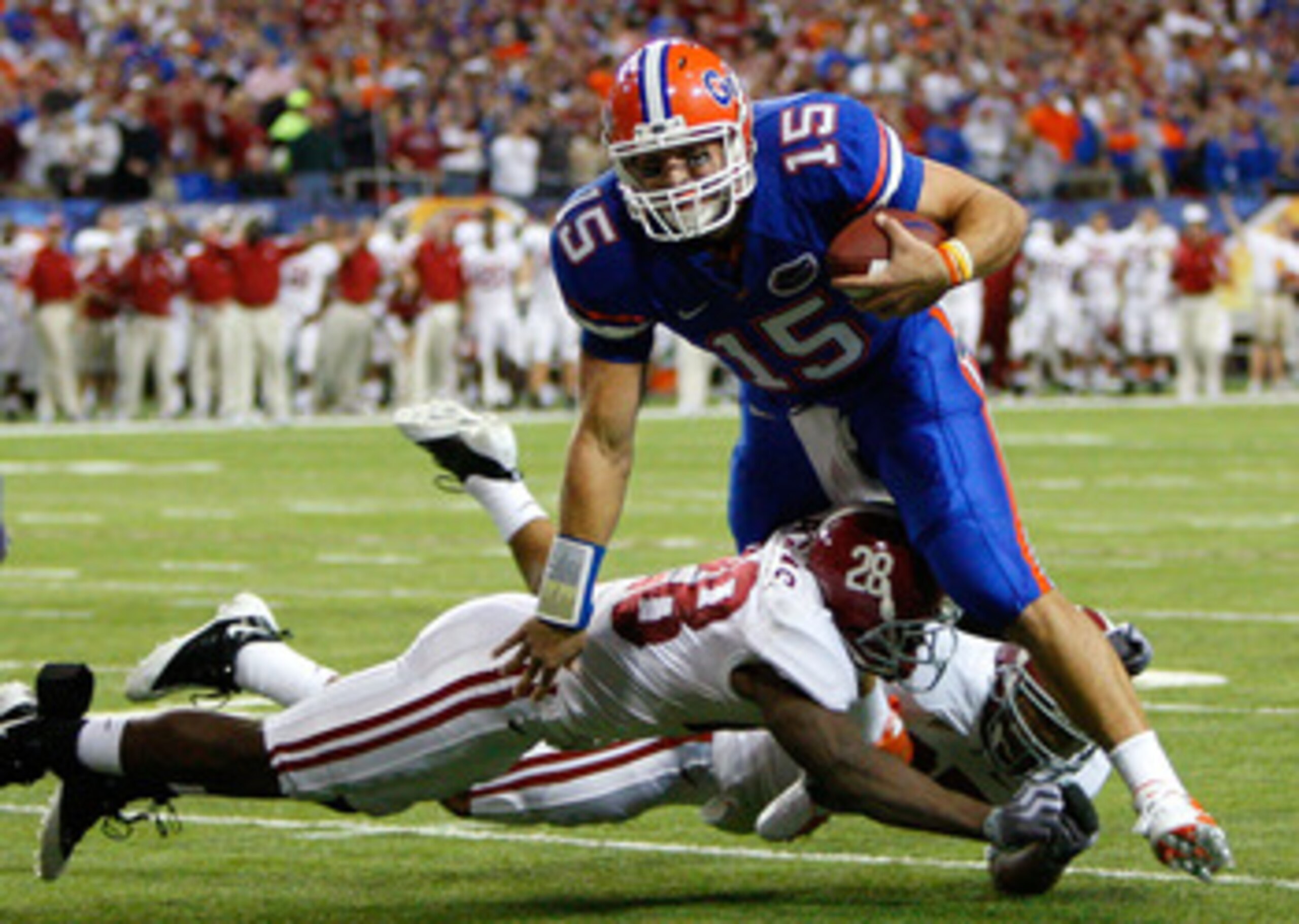 ATLANTA - DECEMBER 06:  Javier Arenas #28 and Justin Woodall #27 of the Alabama Crimson Tide tackle quarterback Tim Tebow #15 of the Florida Gators during the SEC Championship on December 6, 2008 at the Georgia Dome in Atlanta, Georgia.  (Photo by Kevin C