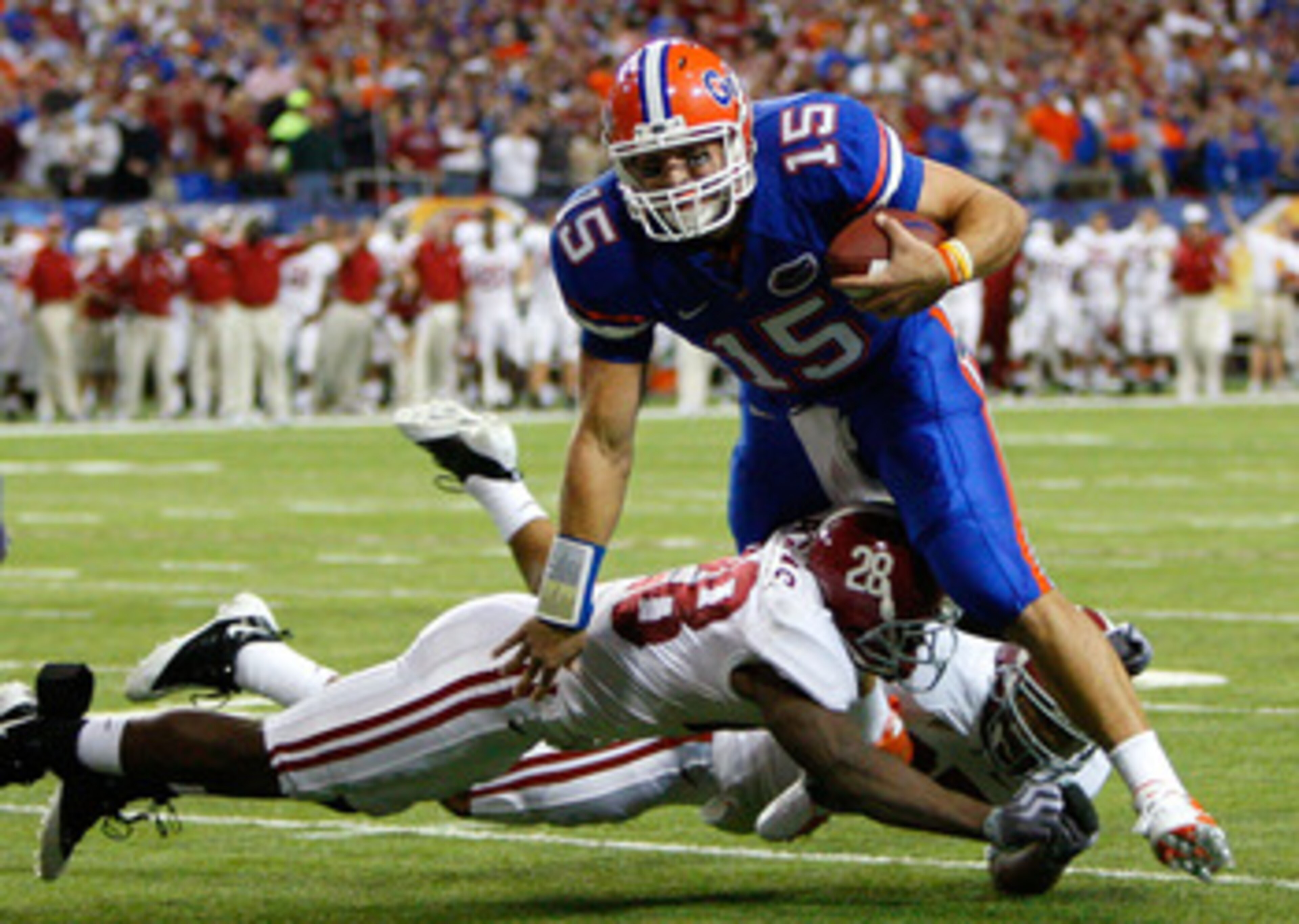 ATLANTA - DECEMBER 06:  Javier Arenas #28 and Justin Woodall #27 of the Alabama Crimson Tide tackle quarterback Tim Tebow #15 of the Florida Gators during the SEC Championship on December 6, 2008 at the Georgia Dome in Atlanta, Georgia.  (Photo by Kevin C