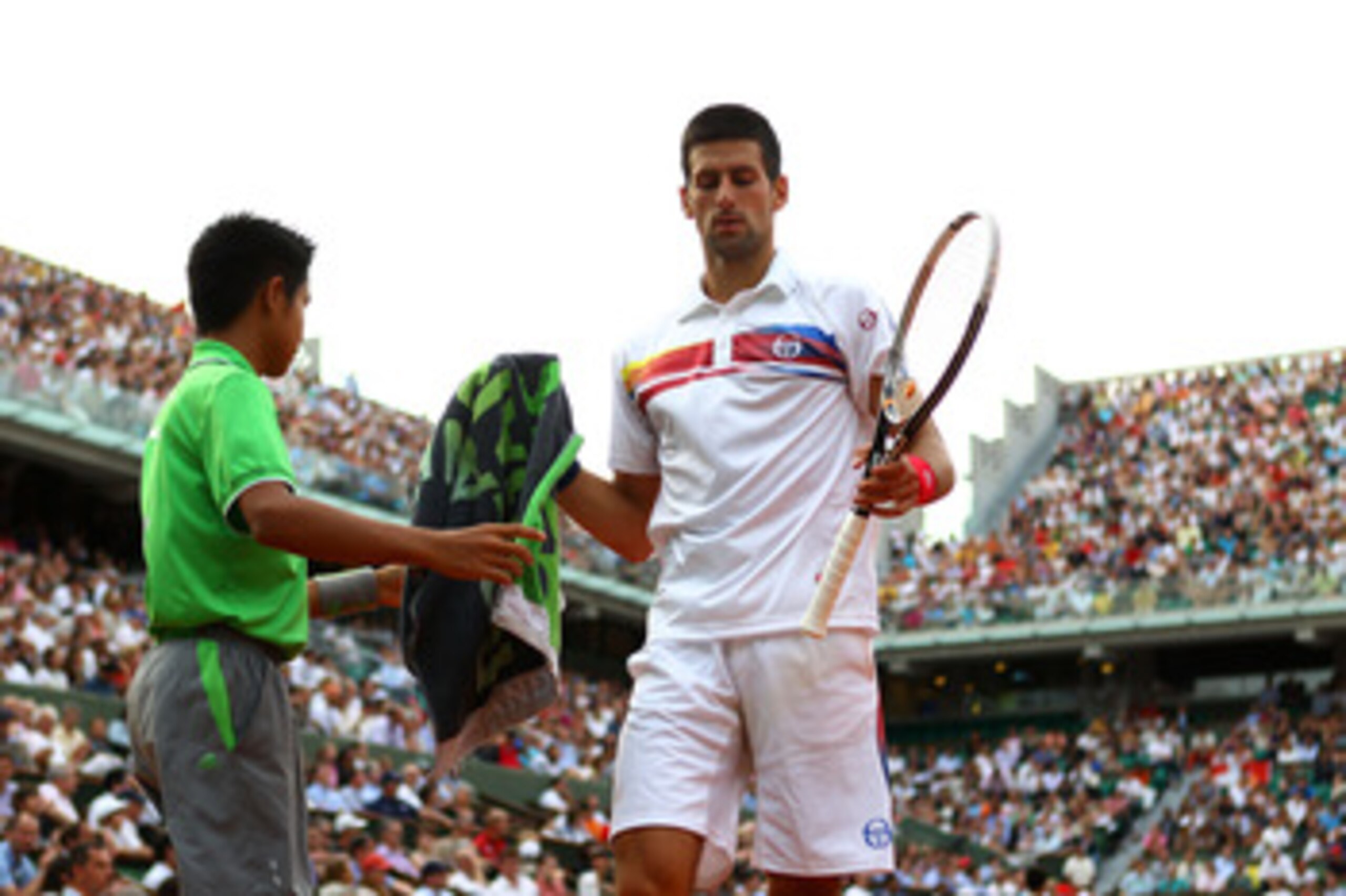 PARIS, FRANCE - JUNE 03:  Novak Djokovic of Serbia towels down between points during the men's singles semi final match between Roger Federer of Switzerland and Novak Djokovic of Serbia on day thirteen of the French Open at Roland Garros on June 3, 2011 i