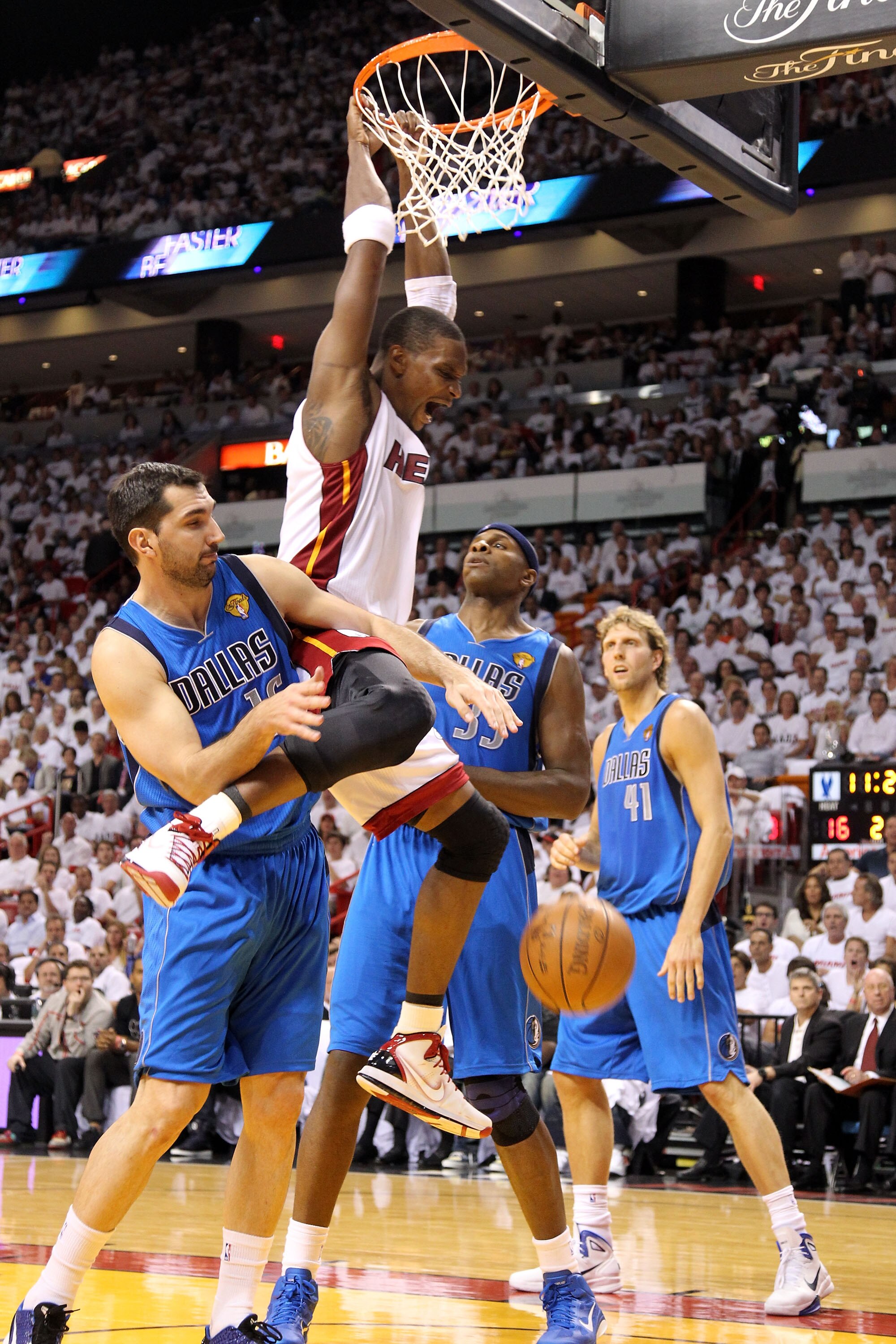 MIAMI, FL - MAY 31:  Chris Bosh #1 of the Miami Heat dunks the ball between Peja Stojakovic #16 and Brendan Haywood #33 of the Dallas Mavericks in the first half in Game One of the 2011 NBA Finals at American Airlines Arena on May 31, 2011 in Miami, Flori