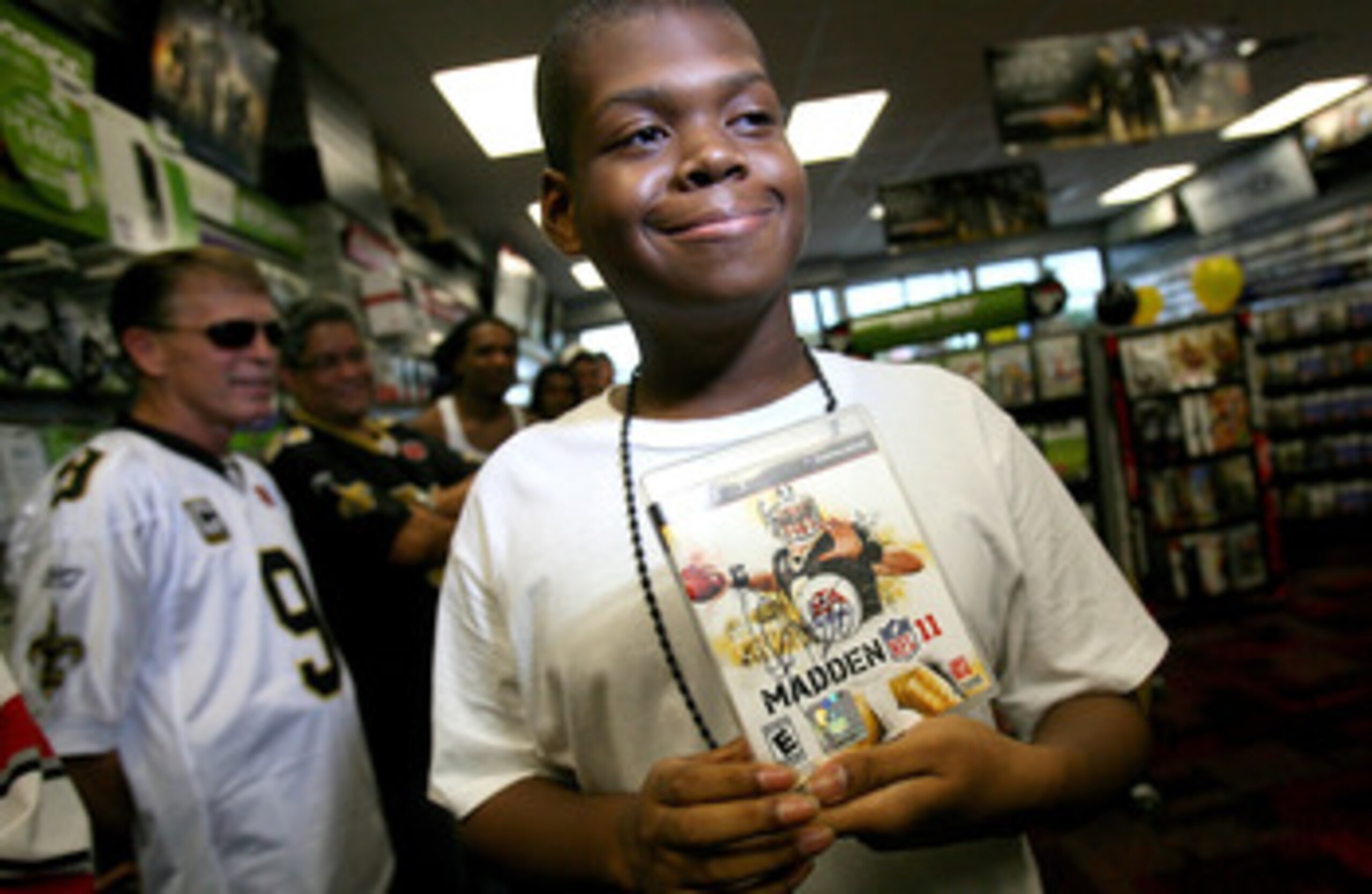 NEW ORLEANS - AUGUST 09: A very happy Ryan Jones, of New Orleans holds the first purchaced Madden NFL 11 video game signed by Marshall Faulk on August 9, 2010 in New Orleans, Louisiana. The game featuring New Orleans Saints quarterback Drew Brees goes on
