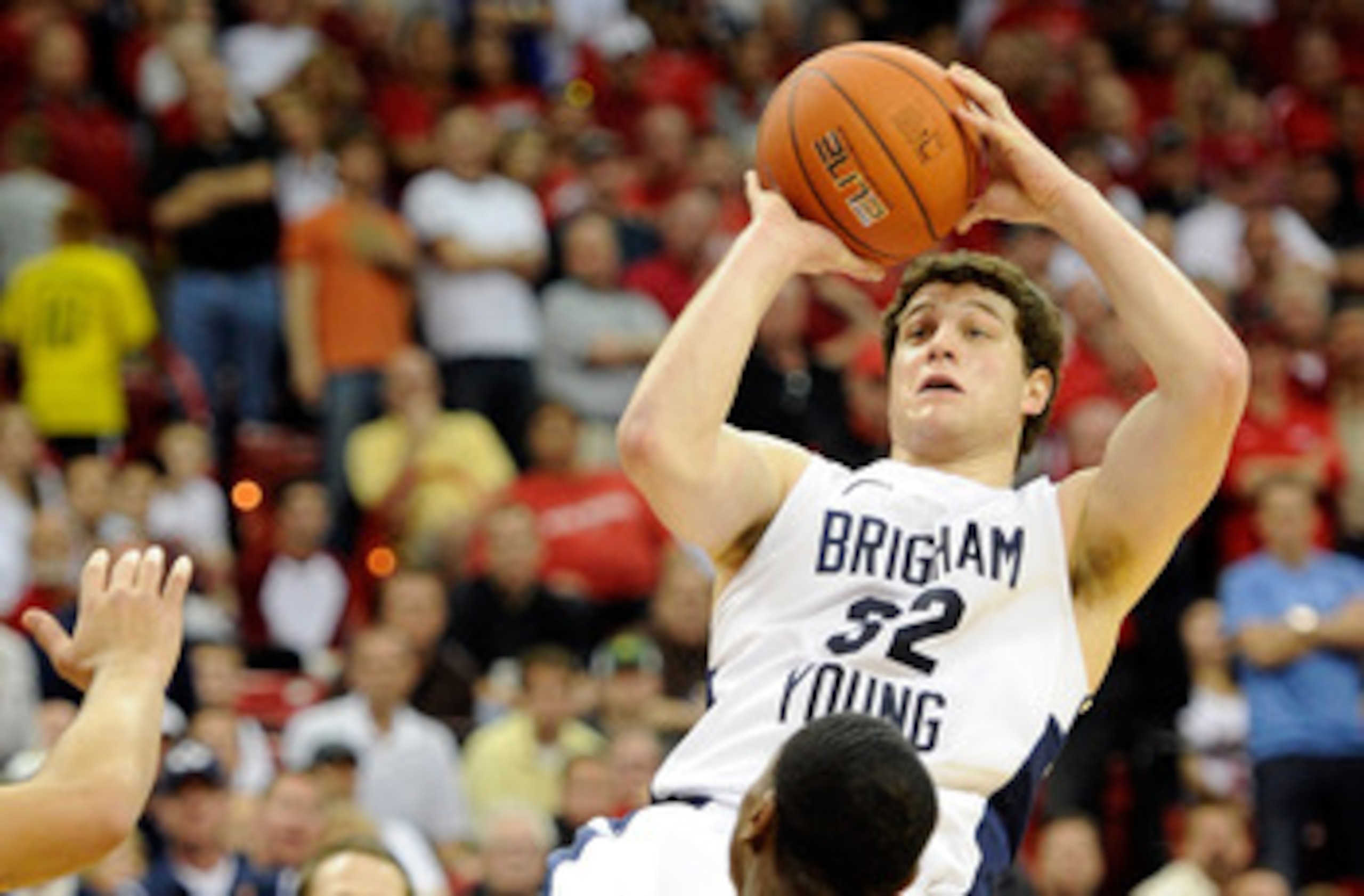 LAS VEGAS, NV - MARCH 11:  Jimmer Fredette #32 of the Brigham Young University Cougars shoots against Jamal Fenton #13 of the New Mexico Lobos during a semifinal game of the Conoco Mountain West Conference Basketball tournament at the Thomas & Mack Center