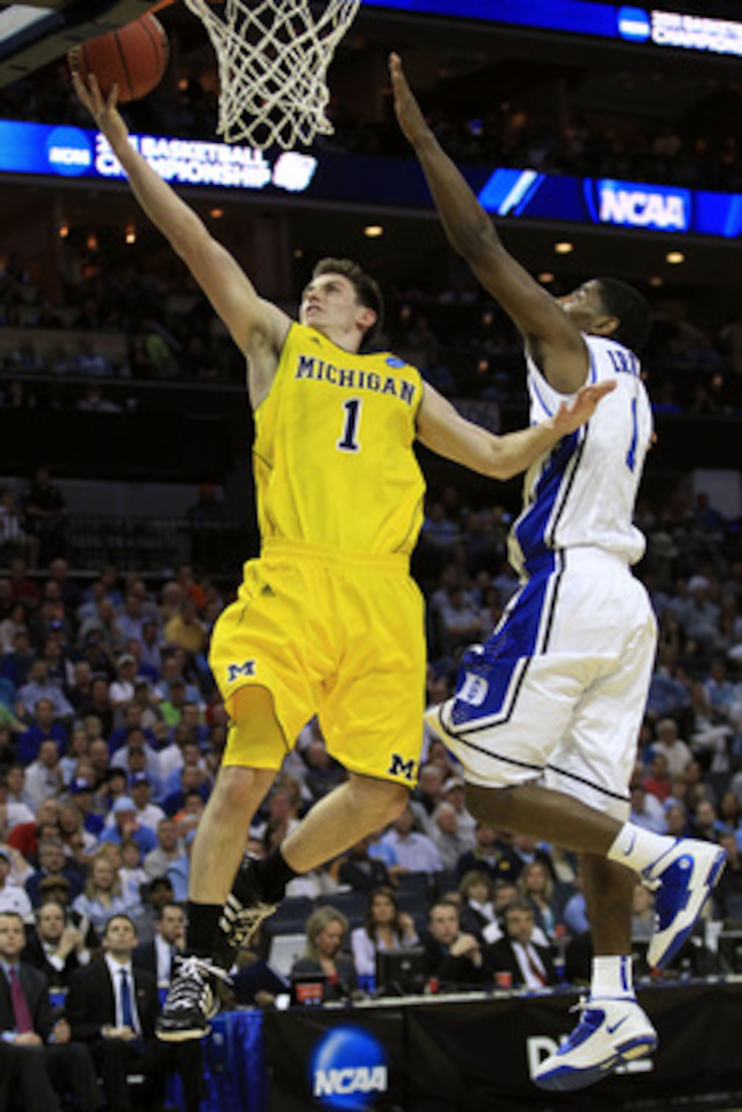 CHARLOTTE, NC - MARCH 20:  Stu Douglass #1 of the Michigan Wolverines goes up for a layup against Kyrie Irving #1 of the Duke Blue Devils in the first half during the third round of the 2011 NCAA men's basketball tournament at Time Warner Cable Arena on M