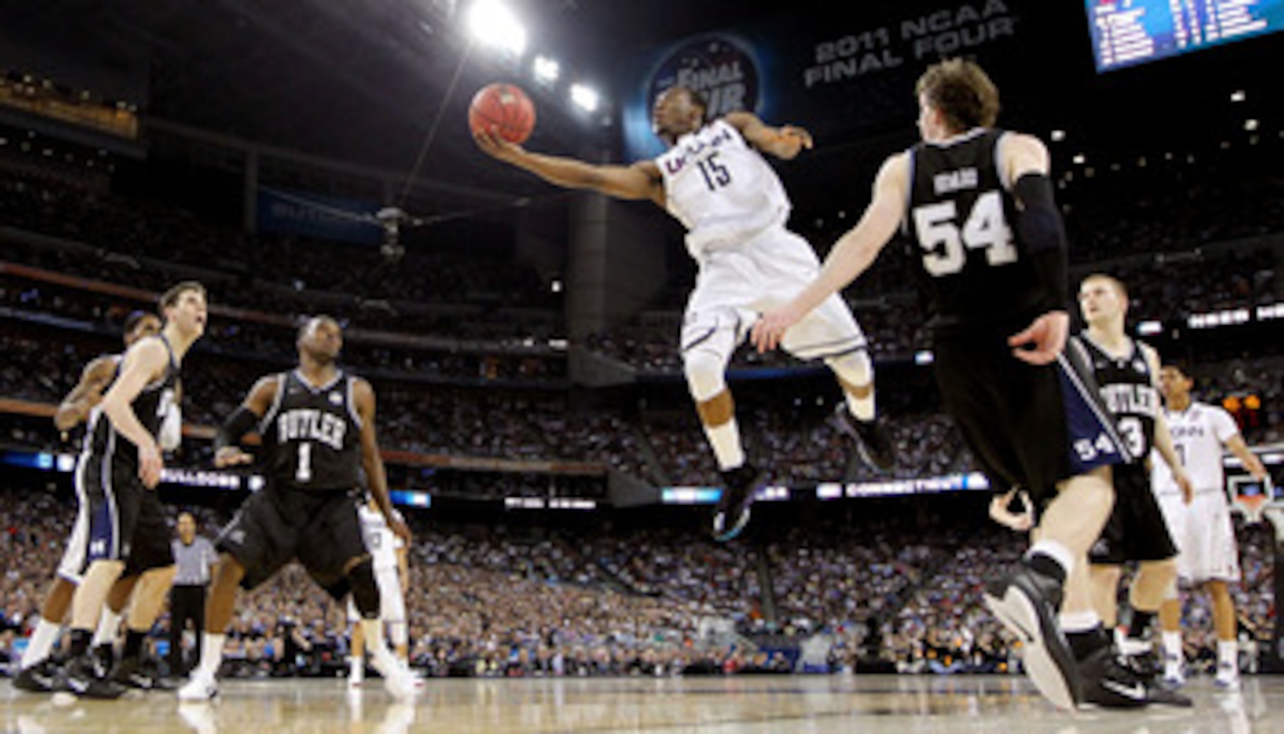 HOUSTON, TX - APRIL 04:  Kemba Walker #15 of the Connecticut Huskies goes to the basket against Matt Howard #54 and Shelvin Mack #1 of the Butler Bulldogs during the National Championship Game of the 2011 NCAA Division I Men's Basketball Tournament at Rel