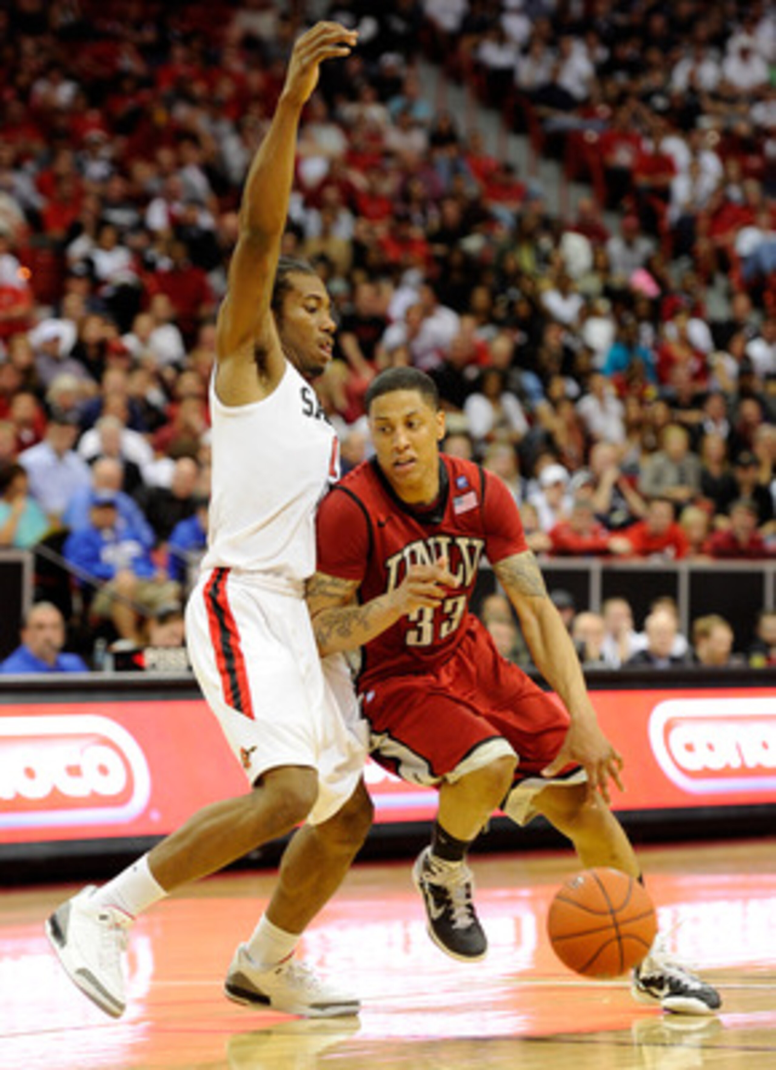 LAS VEGAS, NV - MARCH 11:  Tre'Von Willis #33 of the UNLV Rebels drives against Kawhi Leonard #15 of the San Diego State Aztecs during a semifinal game of the Conoco Mountain West Conference Basketball tournament at the Thomas & Mack Center March 11, 2011
