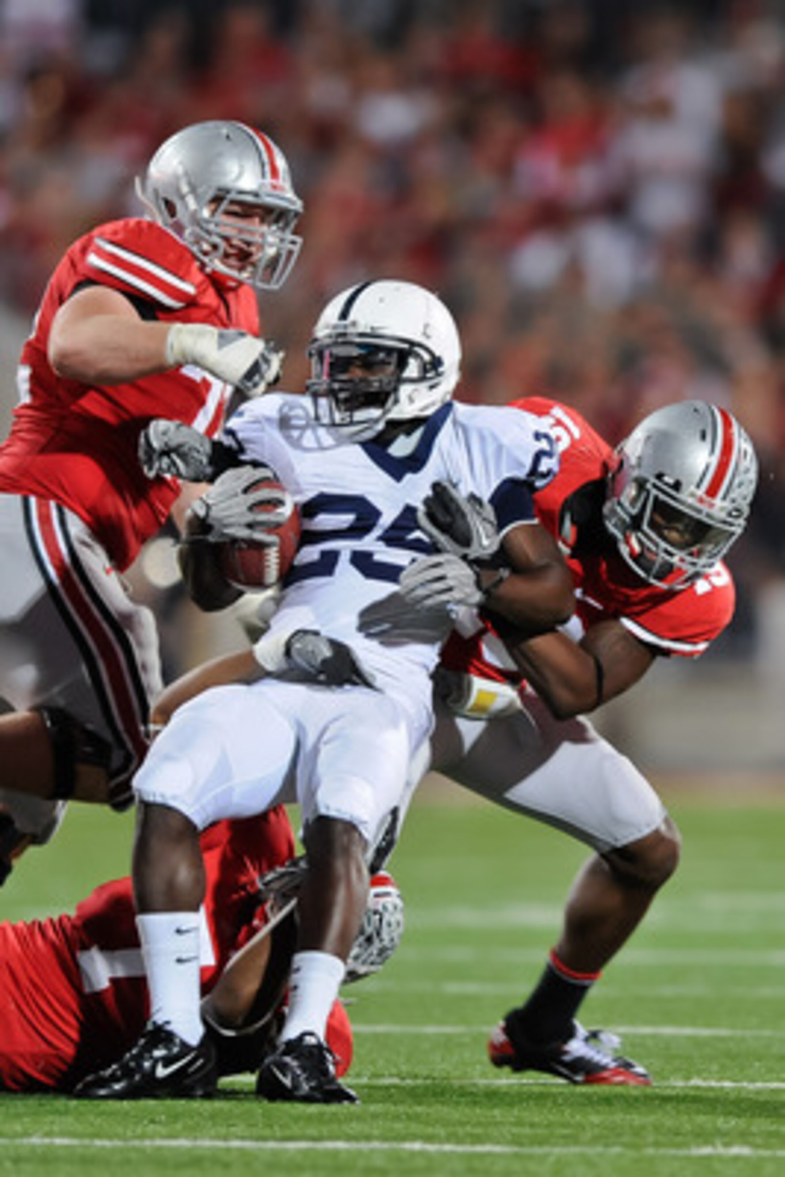 COLUMBUS, OH - NOVEMBER 13: Silas Redd #25 of the Penn State Nittany LIons is tackled by Jermale Hines #7, Orhian Johnson #19 and Dexter Larimore #72, all of the Ohio State Buckeyes at Ohio Stadium on November 13, 2010 in Columbus, Ohio. (Photo by Jamie COLUMBUS, OH - NOVEMBER 13: Silas Redd #25 of the Penn State Nittany LIons is tackled by Jermale Hines #7, Orhian Johnson #19 and Dexter Larimore #72, all of the Ohio State Buckeyes at Ohio Stadium on November 13, 2010 in Columbus, Ohio. (Photo by Jamie