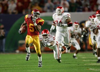 MIAMI - JANUARY 4:  Running back Reggie Bush #5 of the USC Trojans runs upfield against safety Brodney Pool #23 and the Oklahoma Sooners in the 2005 FedEx Orange Bowl National Championship on January 4, 2005 at Pro Player Stadium in Miami, Florida.  USC d