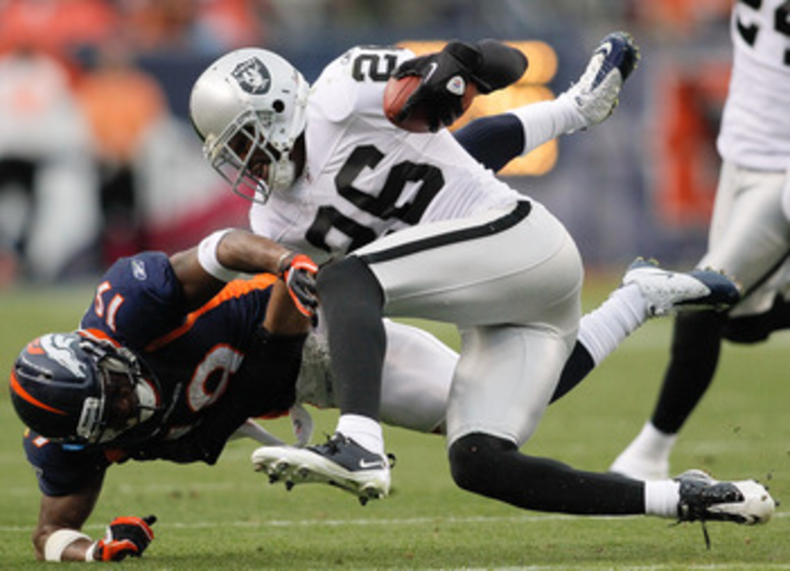 DENVER - OCTOBER 24:  Cornerback Stanford Routt #26 of the Oakland Raiders nearly intercepts a pass intended for wide receiver Eddie Royal #19 in the fourth quarter at INVESCO Field at Mile High on October 24, 2010 in Denver, Colorado. The Raiders defeate