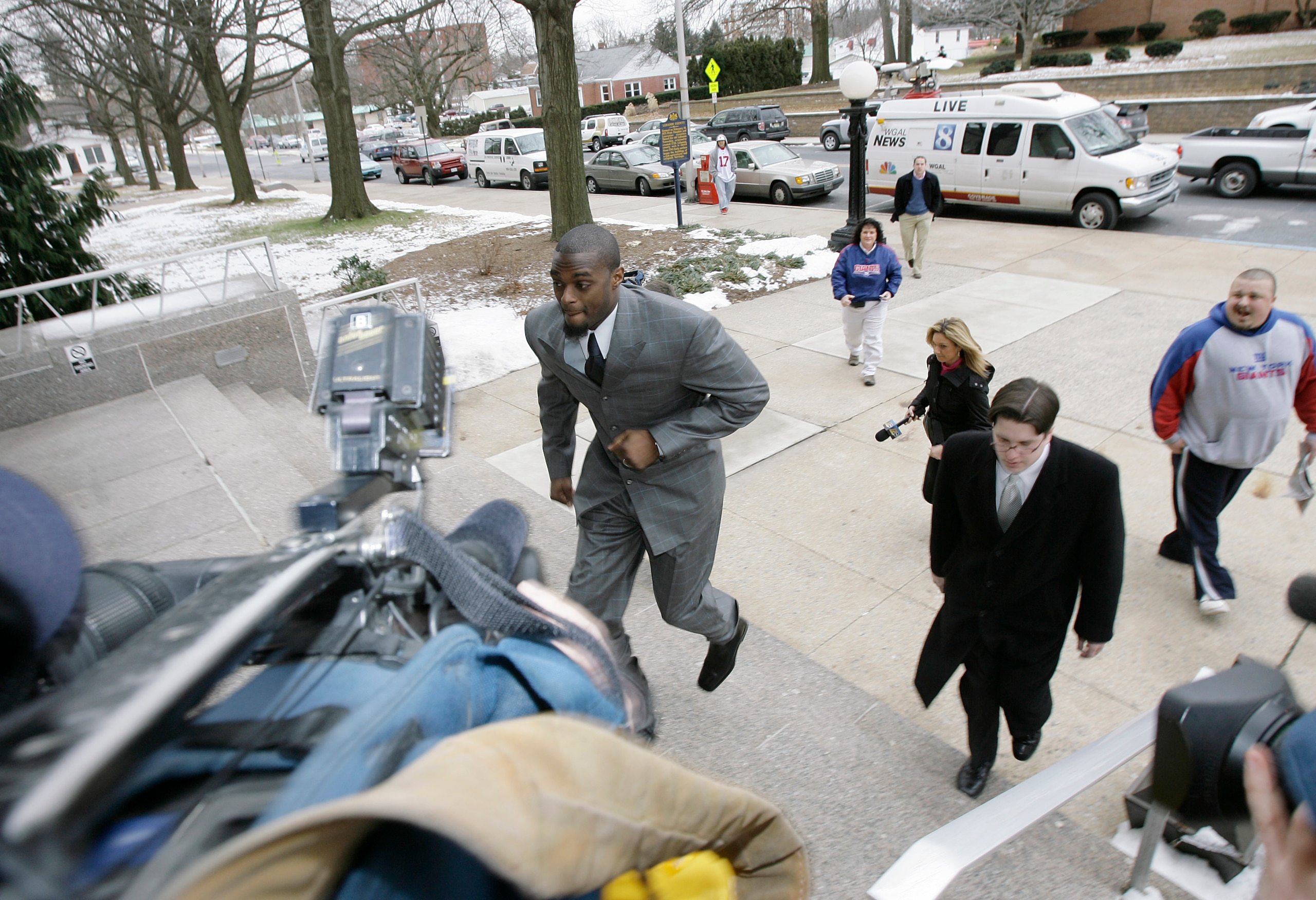 LEBANON - JANUARY 14: New York Giants wide receiver Plaxico Burress runs up the front steps toward members of the media as he arrives at the Lebanon County Courthouse January 14, 2009 in Lebanon, Pa.  Burress is scheduled to appear in a civil trial in a d