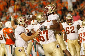 MIAMI, FL - OCTOBER 9: Jermaine Thomas #38 pats Christian Ponder #7 on the head as he is held by Andrew Datko #67 of the Florida State Seminoles after scoring a touchdown against the Miami Hurricanes on October 9, 2010 at Sun Life Stadium in Miami, Florid