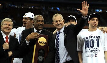 HOUSTON, TX - APRIL 04:  Athletic director Gene Smith of the Ohio State Buckeyes stands with head coach Jim Calhoun of the Connecticut Huskies as the Huskies celebrate with his team and the trophy after defeating the Butler Bulldogs to win the National Ch