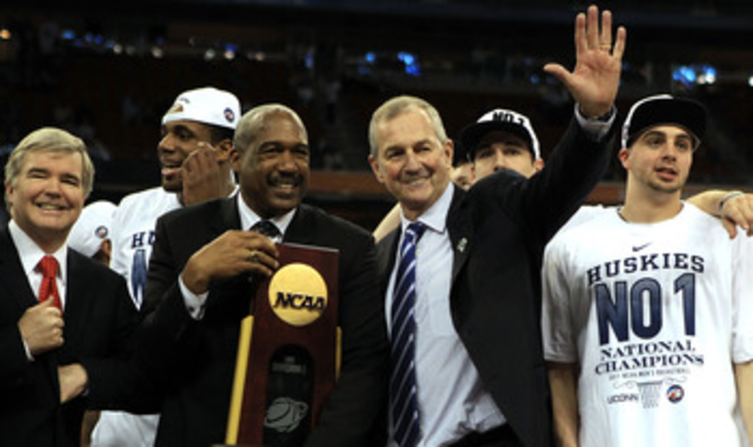 HOUSTON, TX - APRIL 04:  Athletic director Gene Smith of the Ohio State Buckeyes stands with head coach Jim Calhoun of the Connecticut Huskies as the Huskies celebrate with his team and the trophy after defeating the Butler Bulldogs to win the National Ch